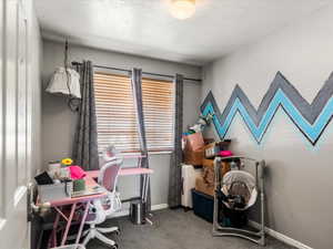 Carpeted interior room with a window featuring horizontal blinds