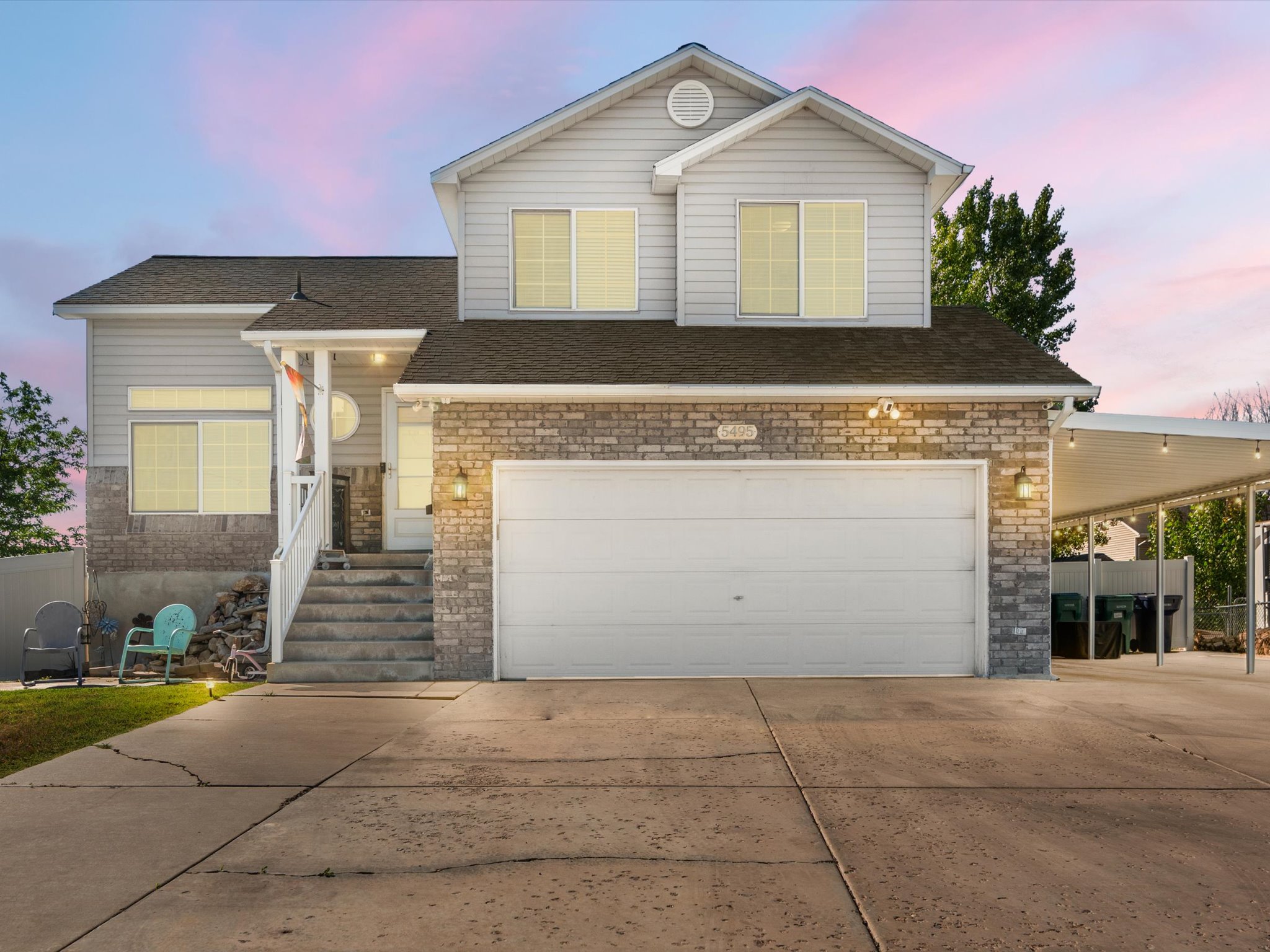 Two-story residence featuring light gray siding and a stone facade