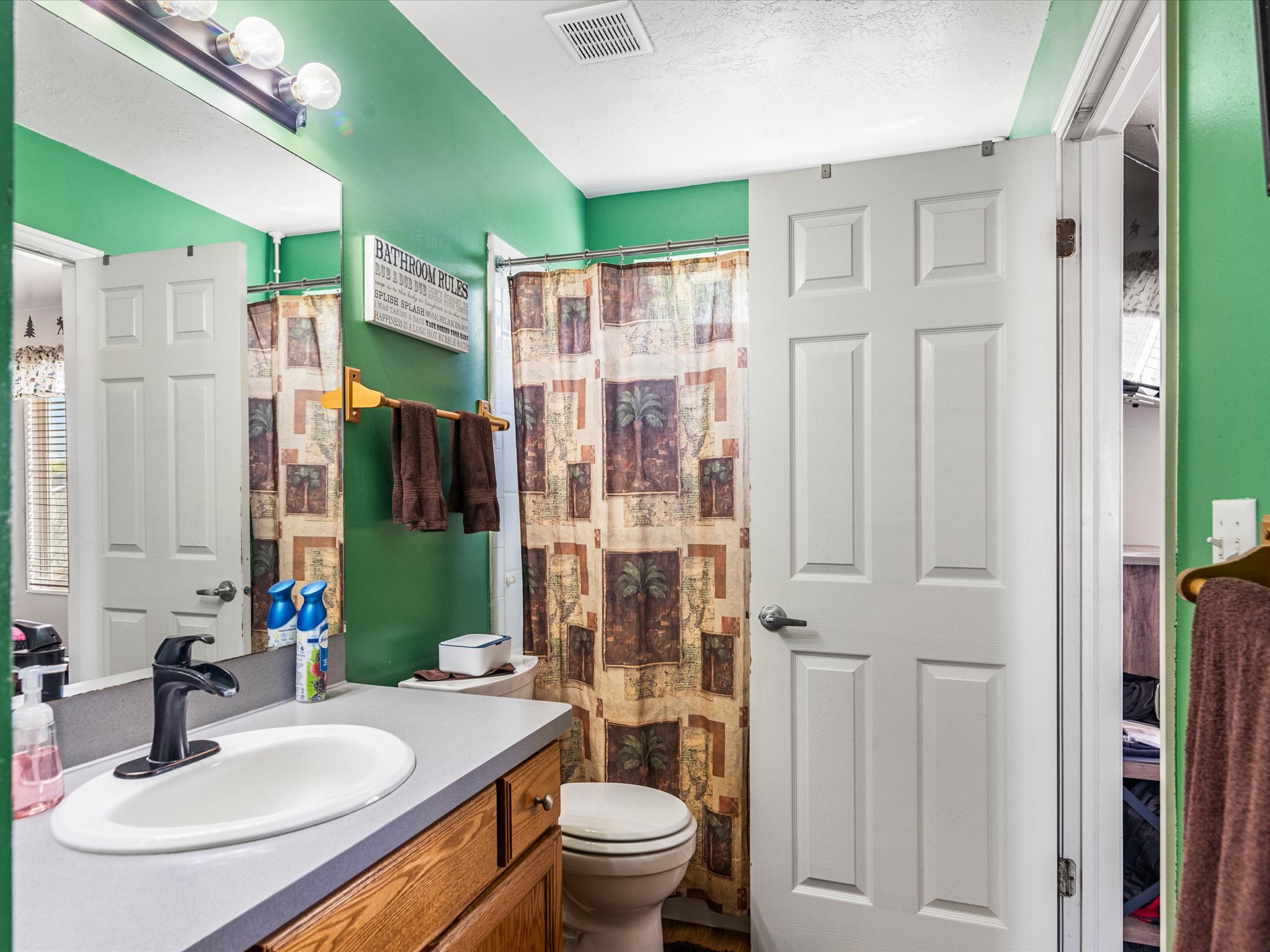 Bathroom featuring a vanity with an integrated sink, a dark faucet, and wood-finish cabinetry