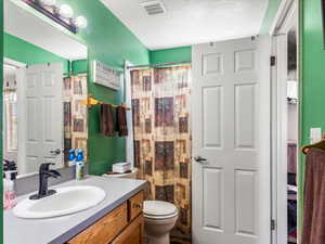 Bathroom featuring a vanity with an integrated sink, a dark faucet, and wood-finish cabinetry