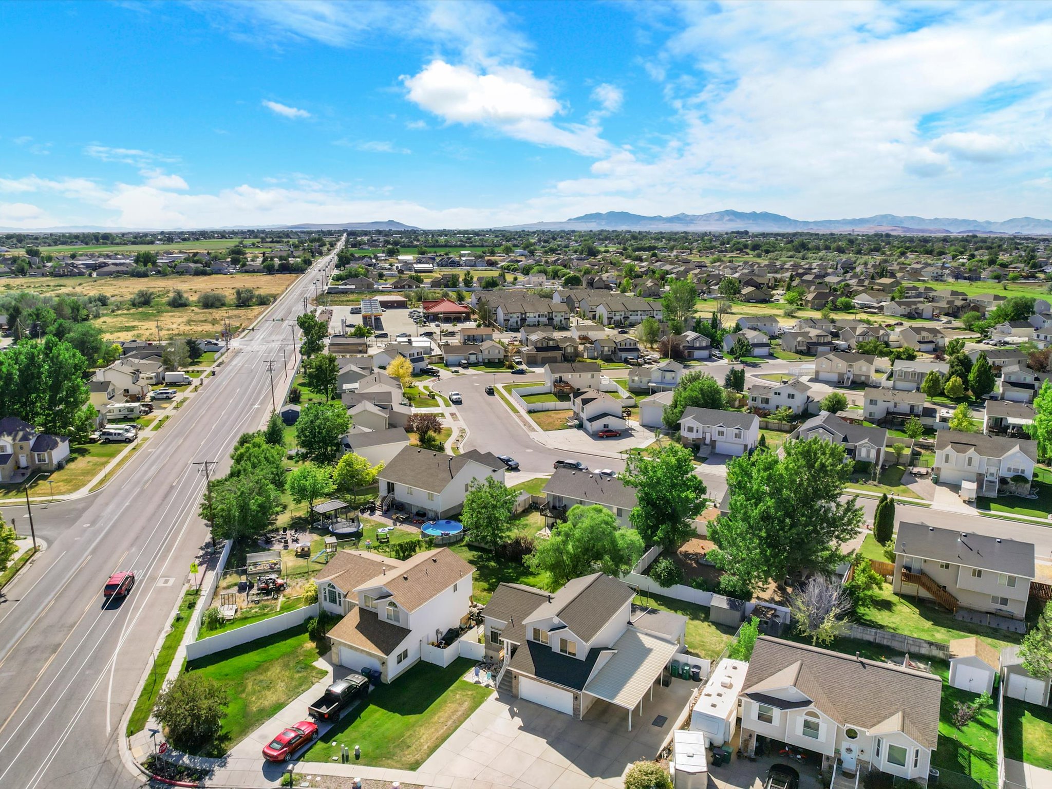 Expansive aerial perspective showcasing a residential neighborhood with distant mountain ranges