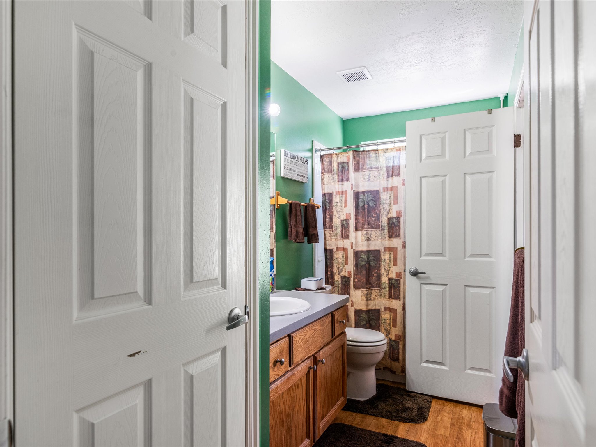 Bathroom featuring a single vanity with wood-finish cabinetry and a light-colored countertop
