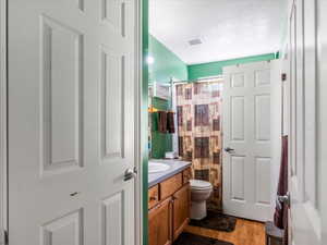 Bathroom featuring a single vanity with wood-finish cabinetry and a light-colored countertop
