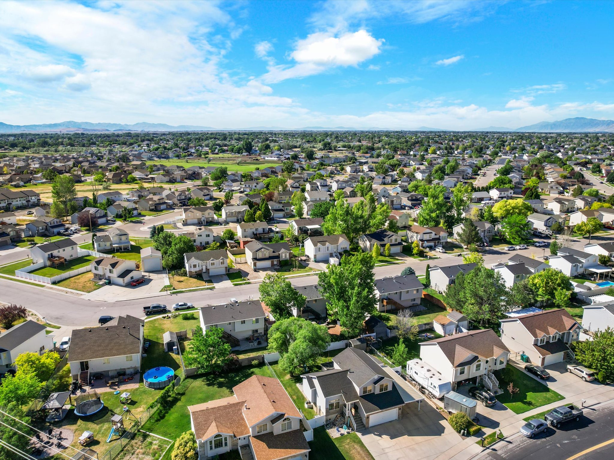Residential neighborhood featuring a variety of single-family homes, mature trees, and paved streets