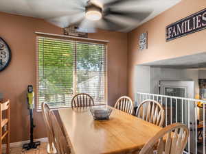 Dining area with a large window, ceiling fan, and wood-finish flooring