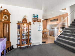 Carpeted staircase with white balusters leading to an upper level