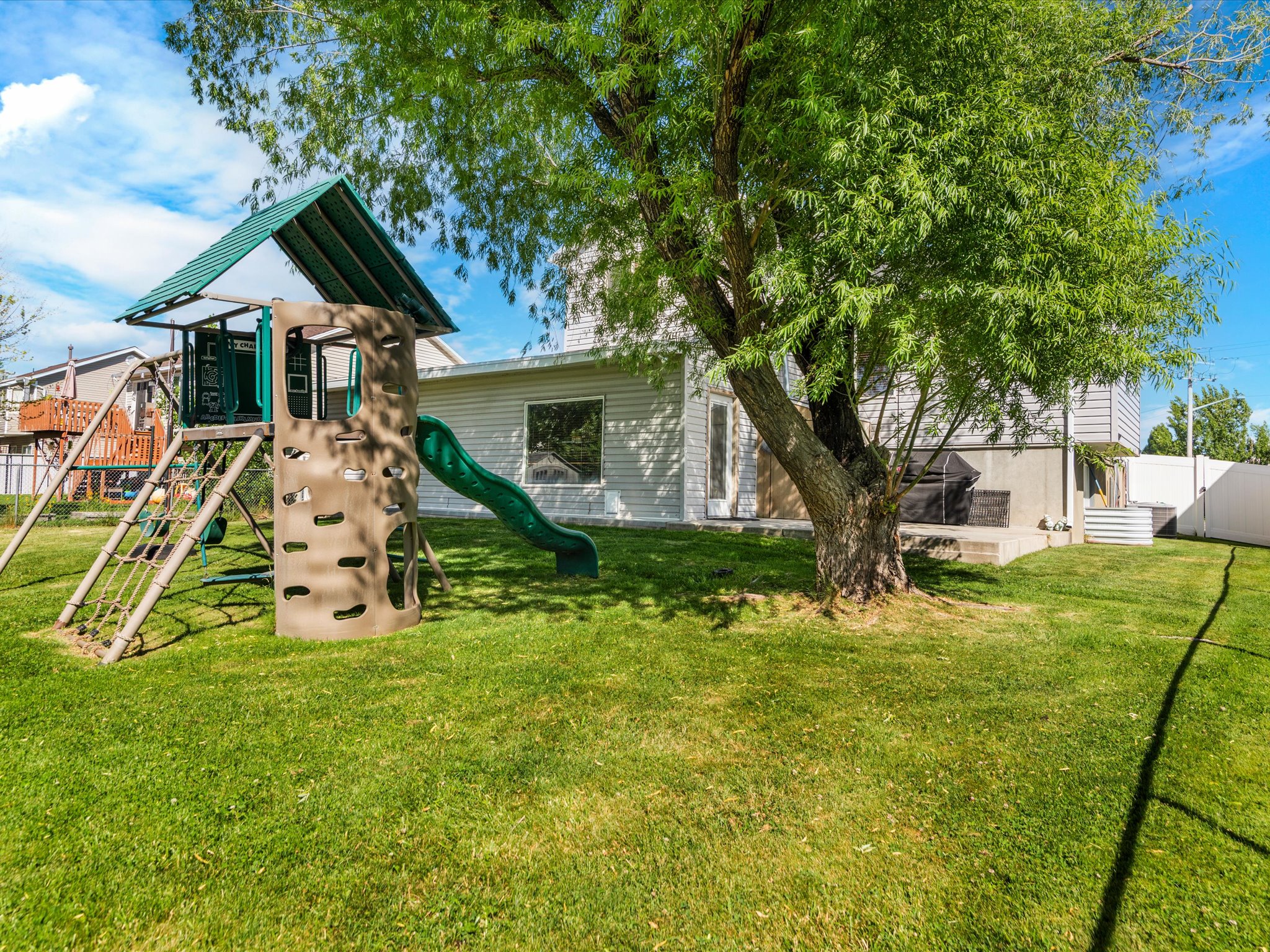 Expansive green lawn with a mature deciduous tree