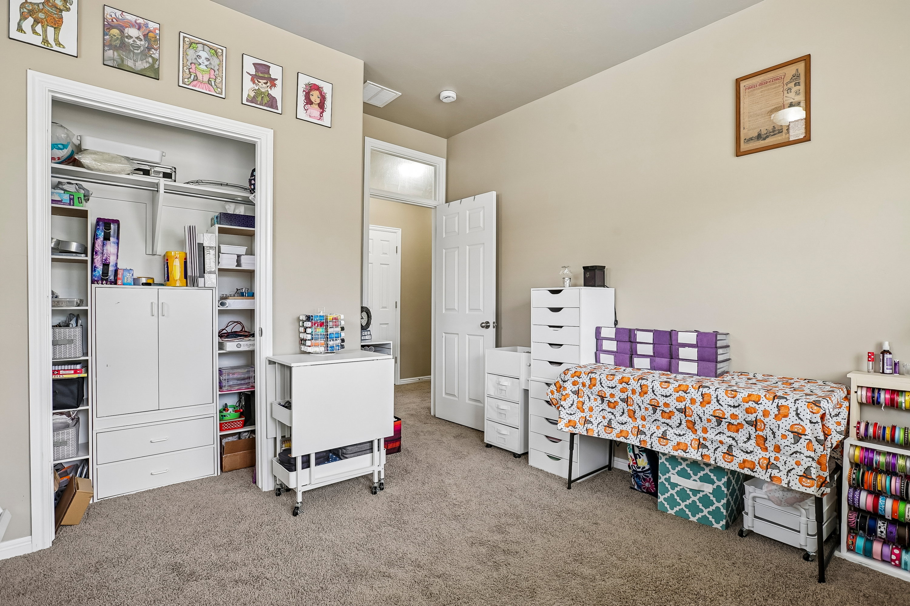 Carpeted room featuring a built-in closet with shelving, a white paneled door, and neutral wall tones