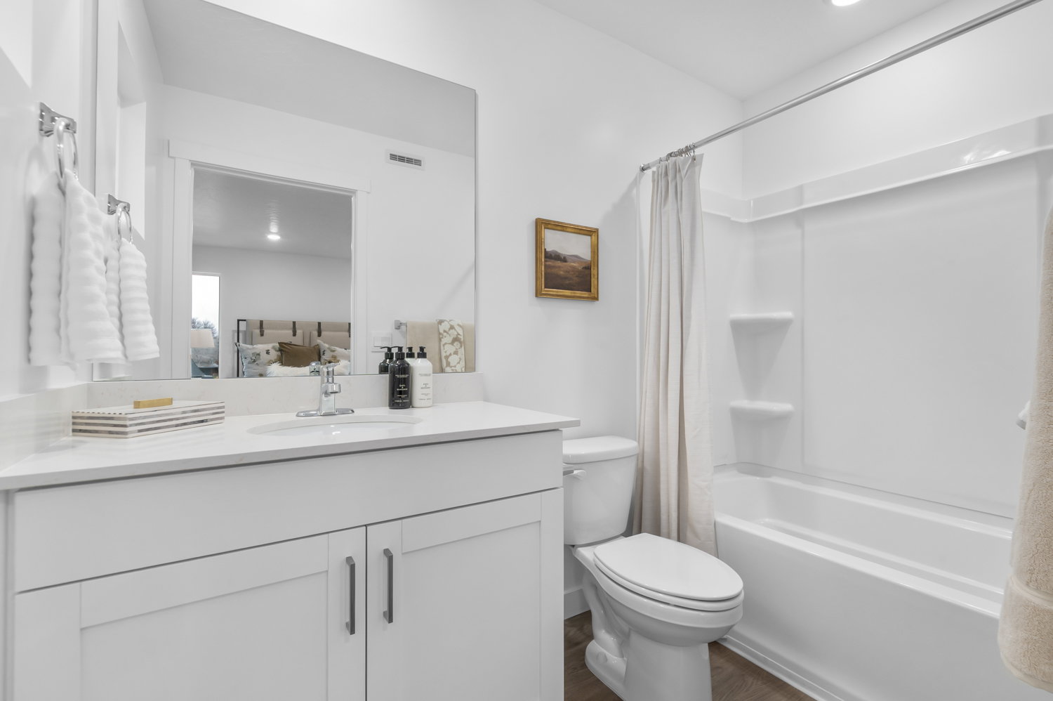 Bathroom featuring a white vanity with a light-toned countertop, an integrated sink with a chrome faucet, and a large wall-mounted mirror