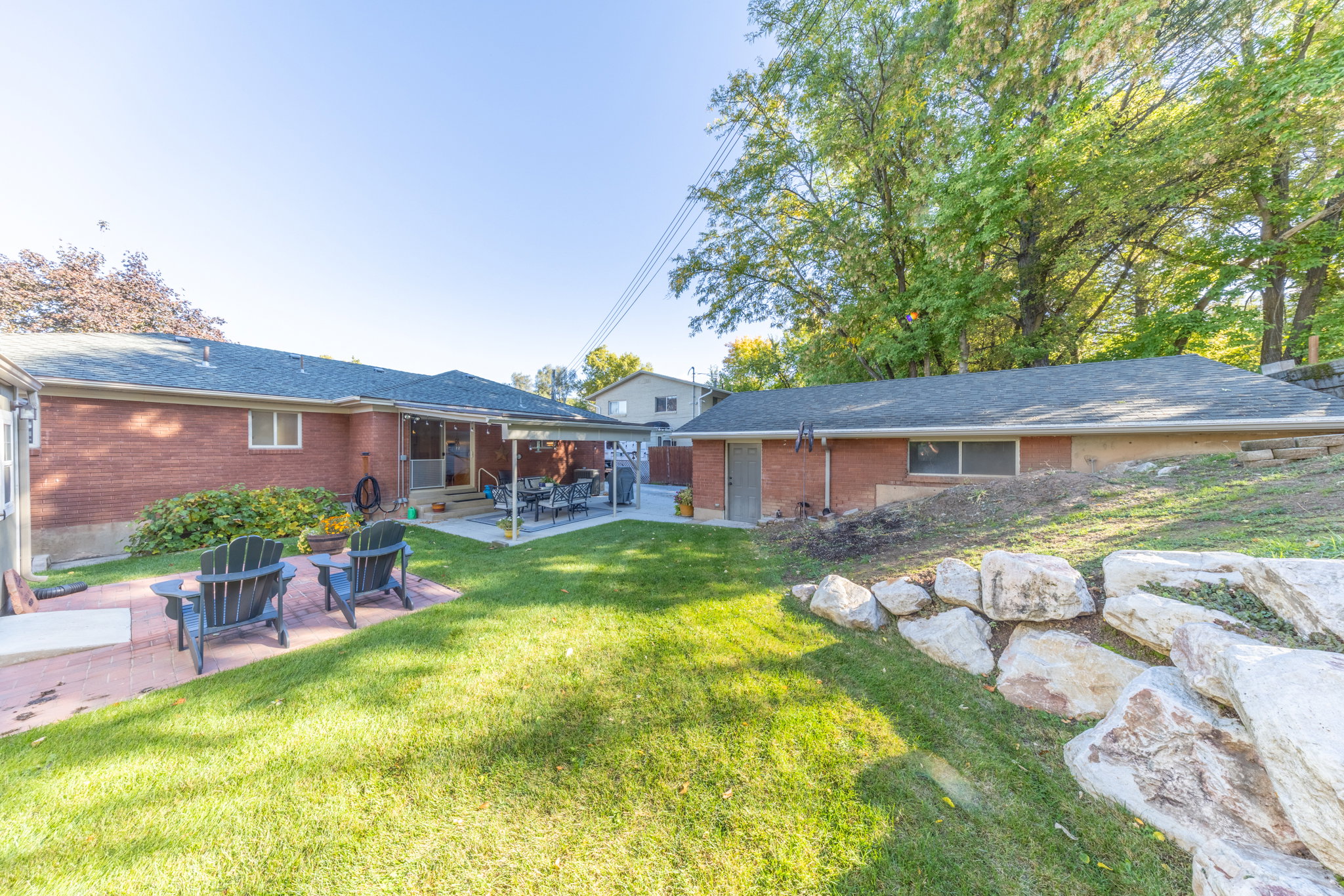 Expansive green lawn with a patio area and an additional covered patio space