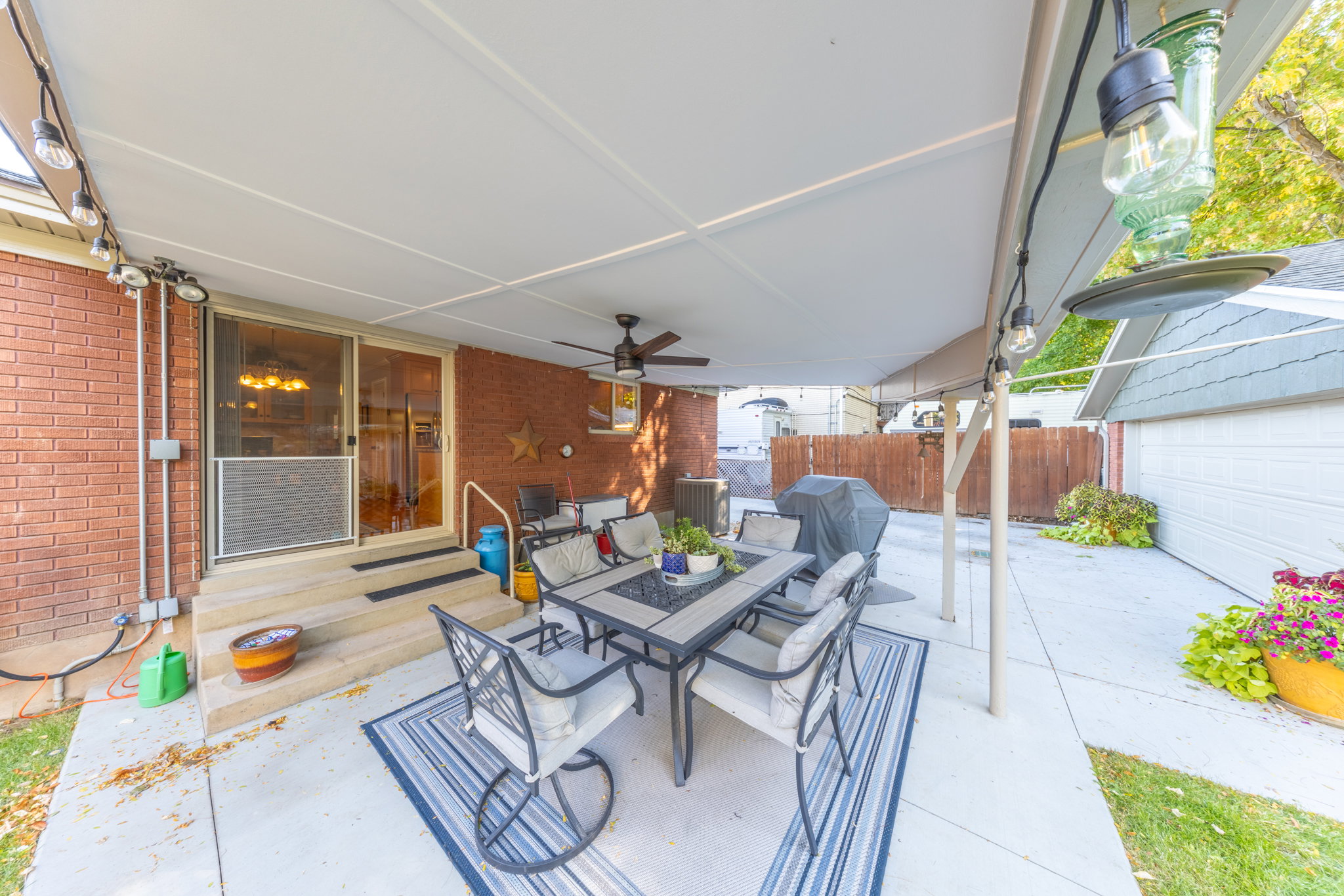Covered patio featuring a ceiling fan, string lighting, and direct access to the interior via sliding glass doors
