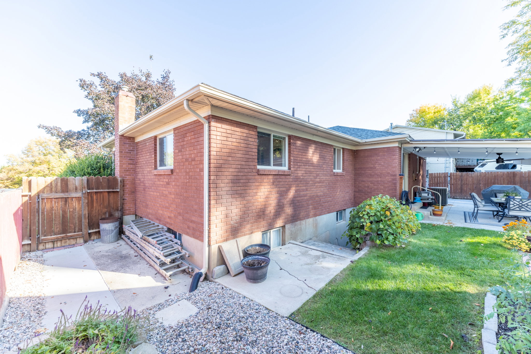 Exterior brick facade featuring multiple windows and a covered patio area