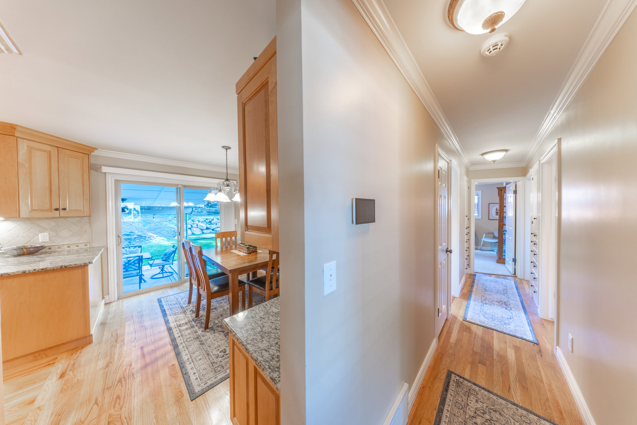 Kitchen and hallway with light wood-finish flooring