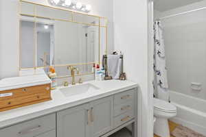 Bathroom vanity featuring a gold-framed mirror and a four-bulb light fixture