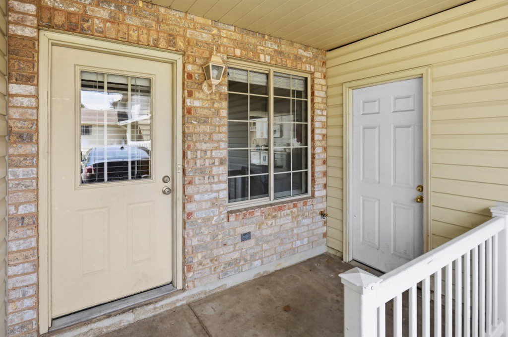 Entryway featuring brick veneer and light-toned siding
