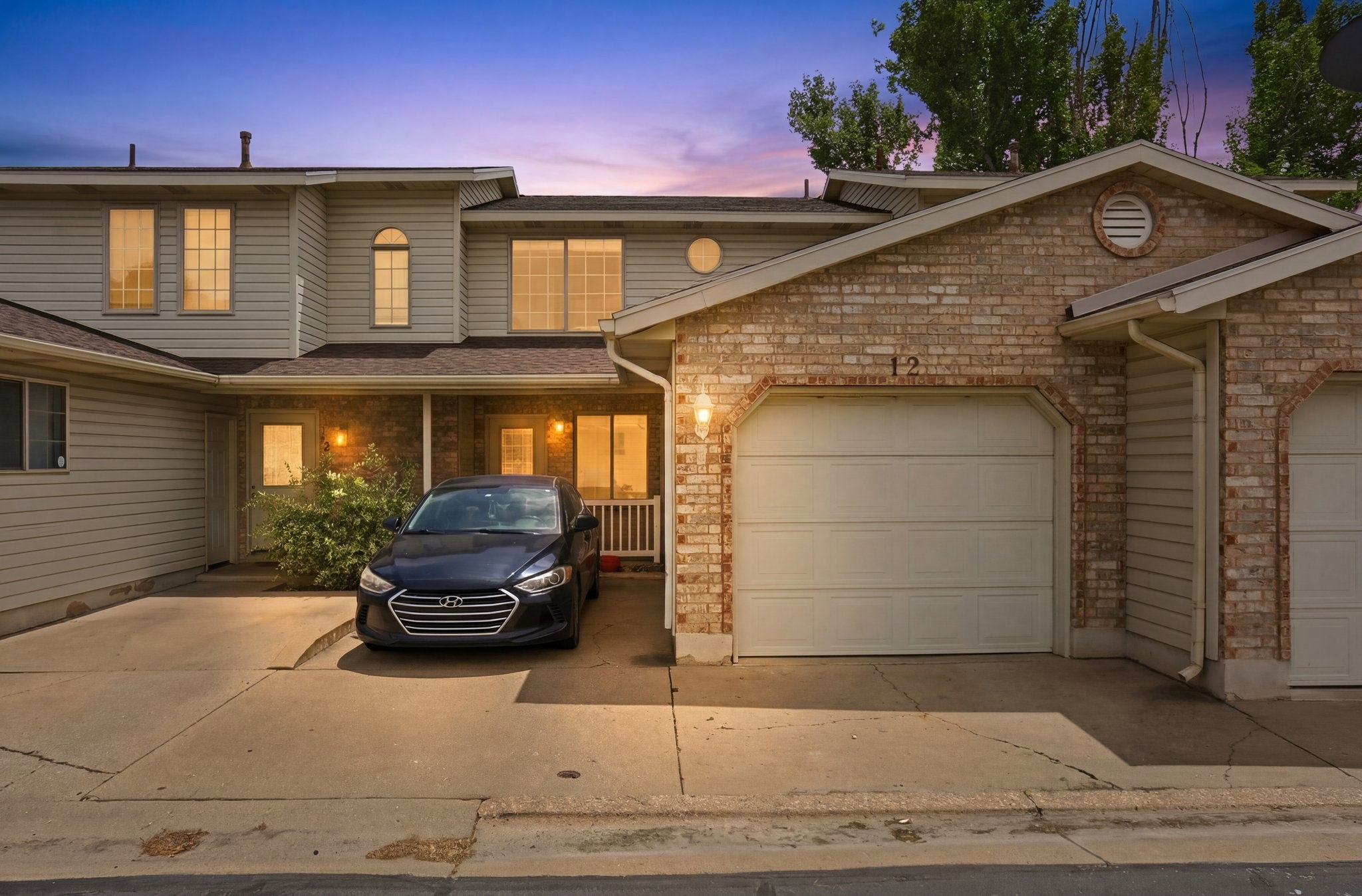 Brick and siding exterior featuring an attached garage with a concrete driveway