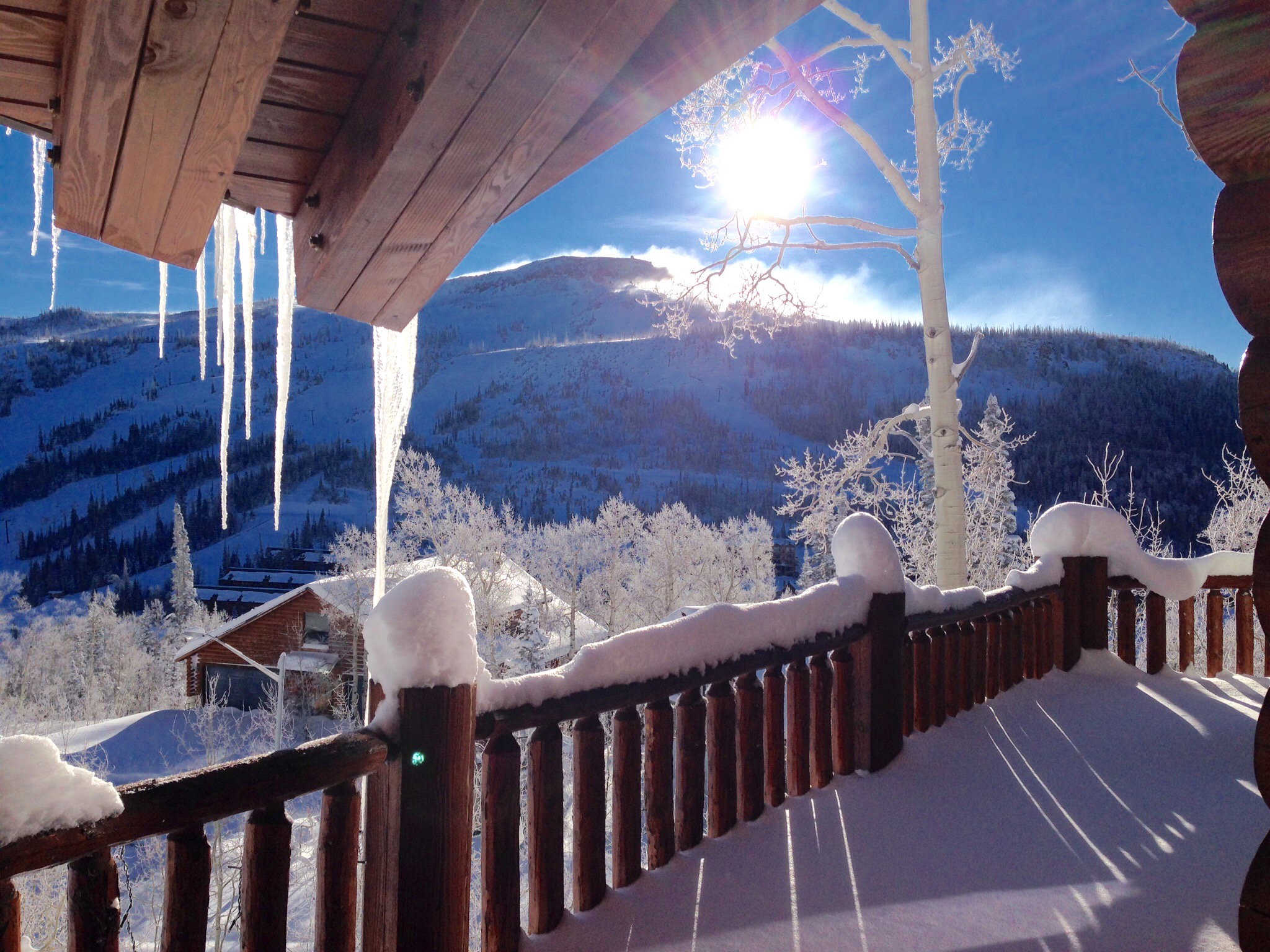 Balcony with rustic wooden railing and substantial overhead beams