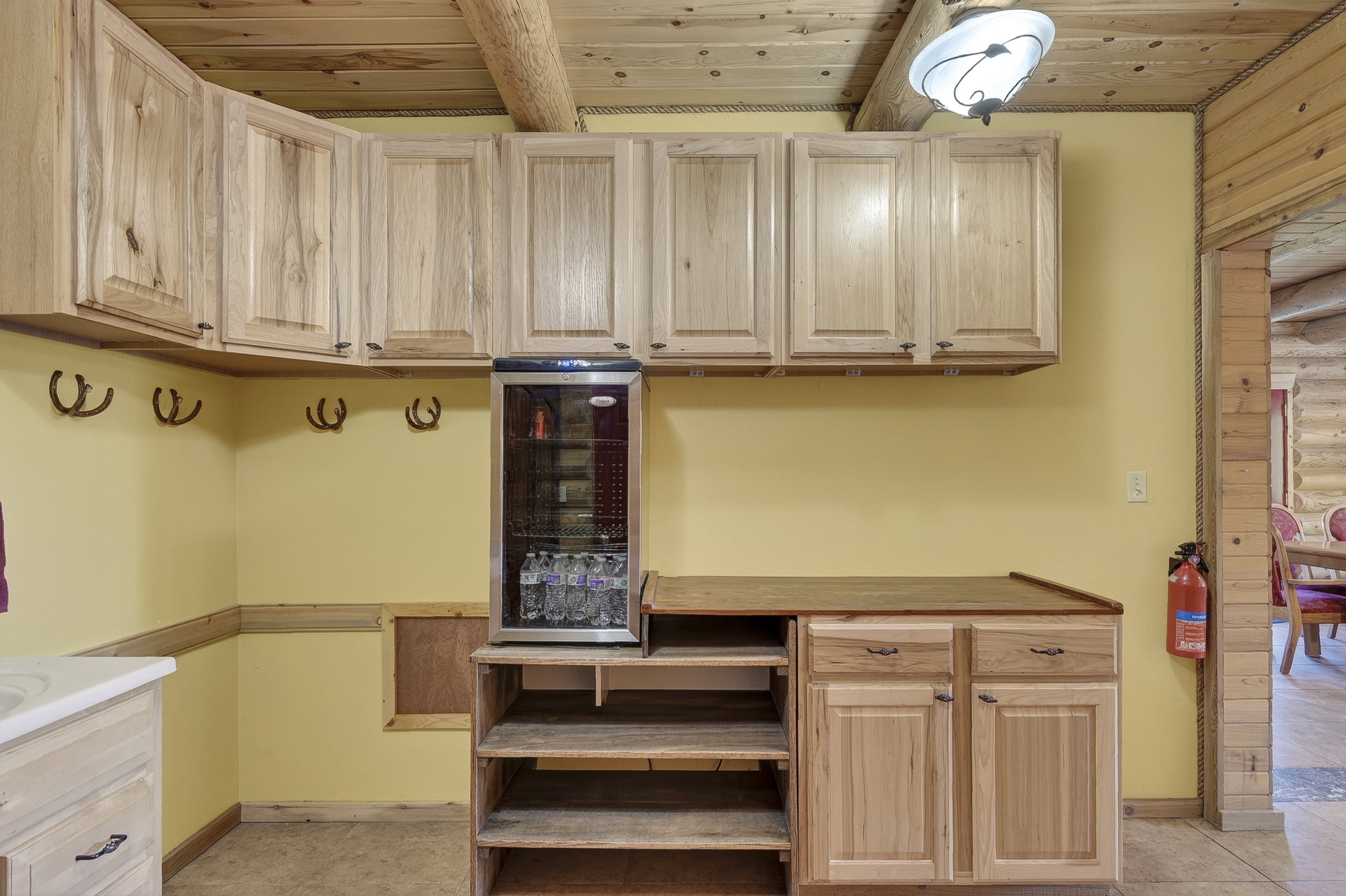 Wood-finish cabinetry and ceiling with exposed log beams