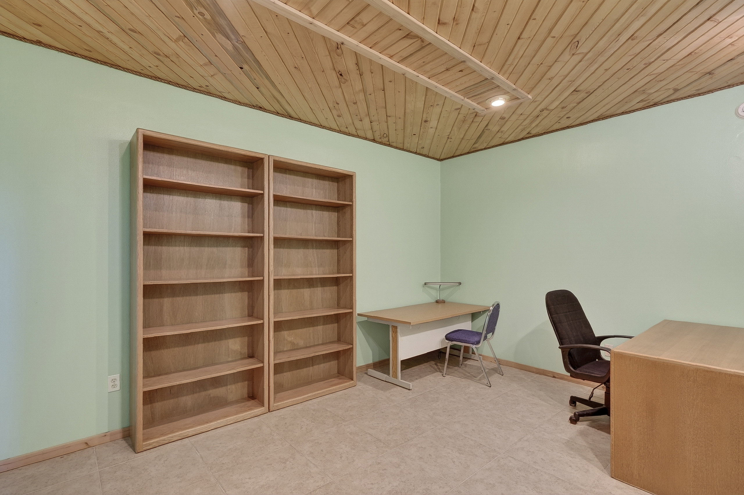 Room featuring a light wood plank ceiling, neutral flooring, and light green walls
