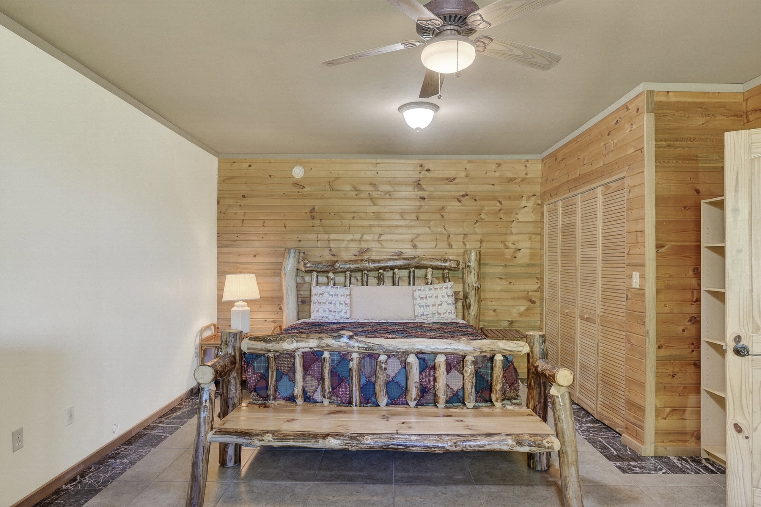 Room featuring a full wood-plank accent wall, light-colored walls, and dark flooring