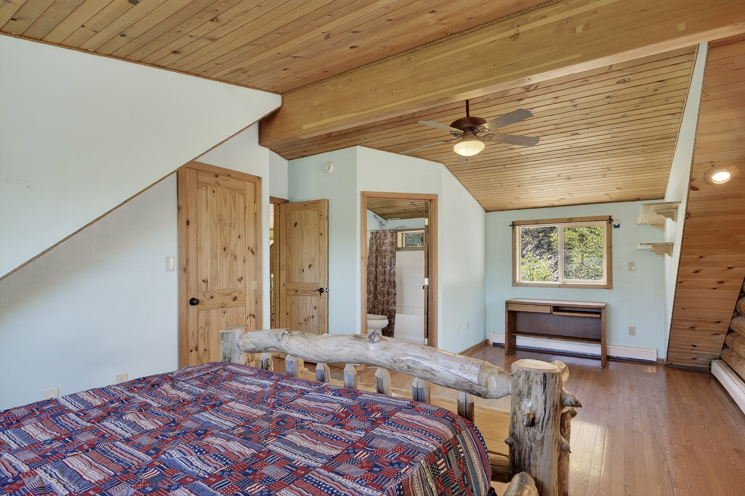 Wood-finish plank ceilings and matching wood-finish flooring characterize this room