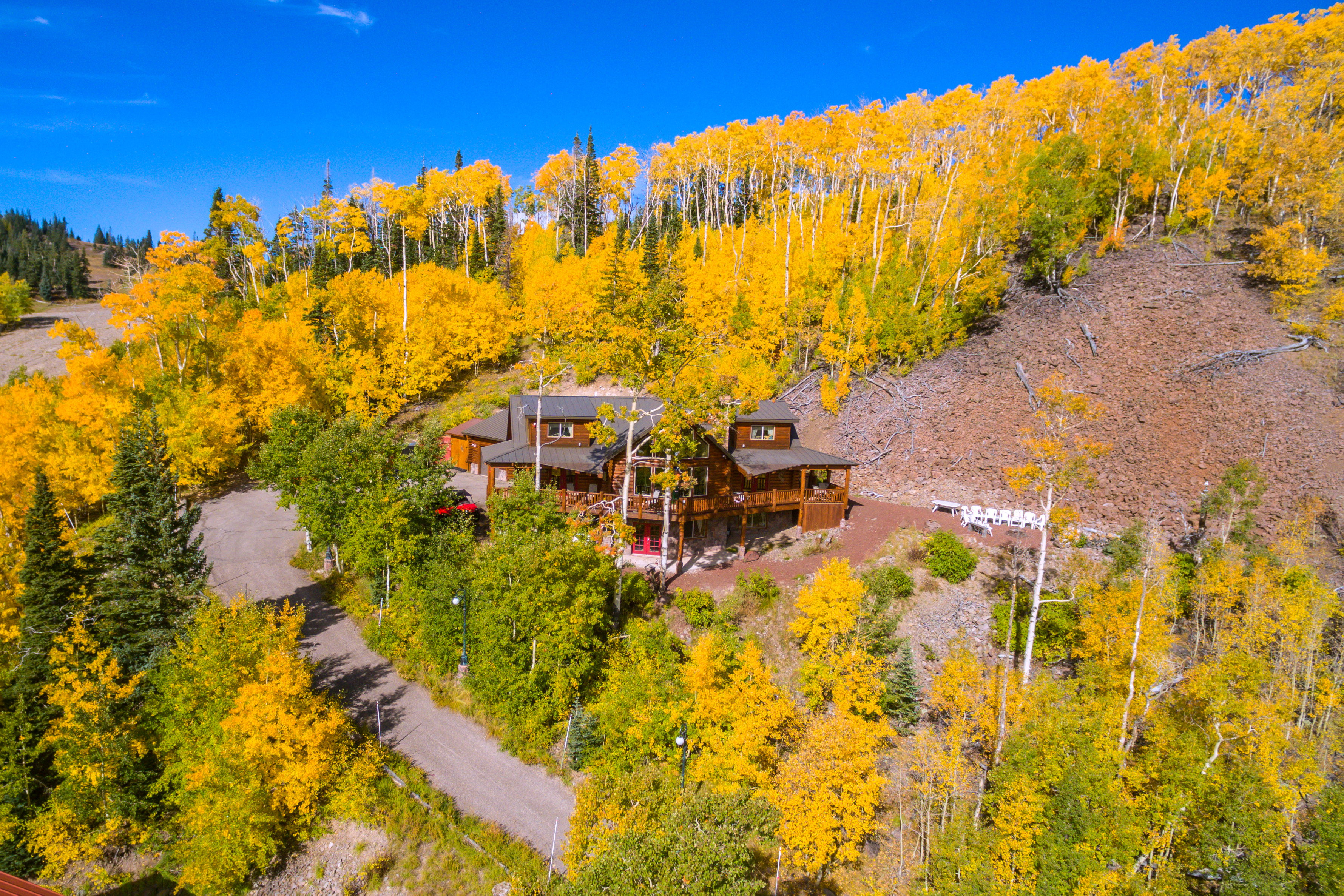 Rustic-style residence situated on a hillside, featuring extensive wrap-around decking and multiple levels