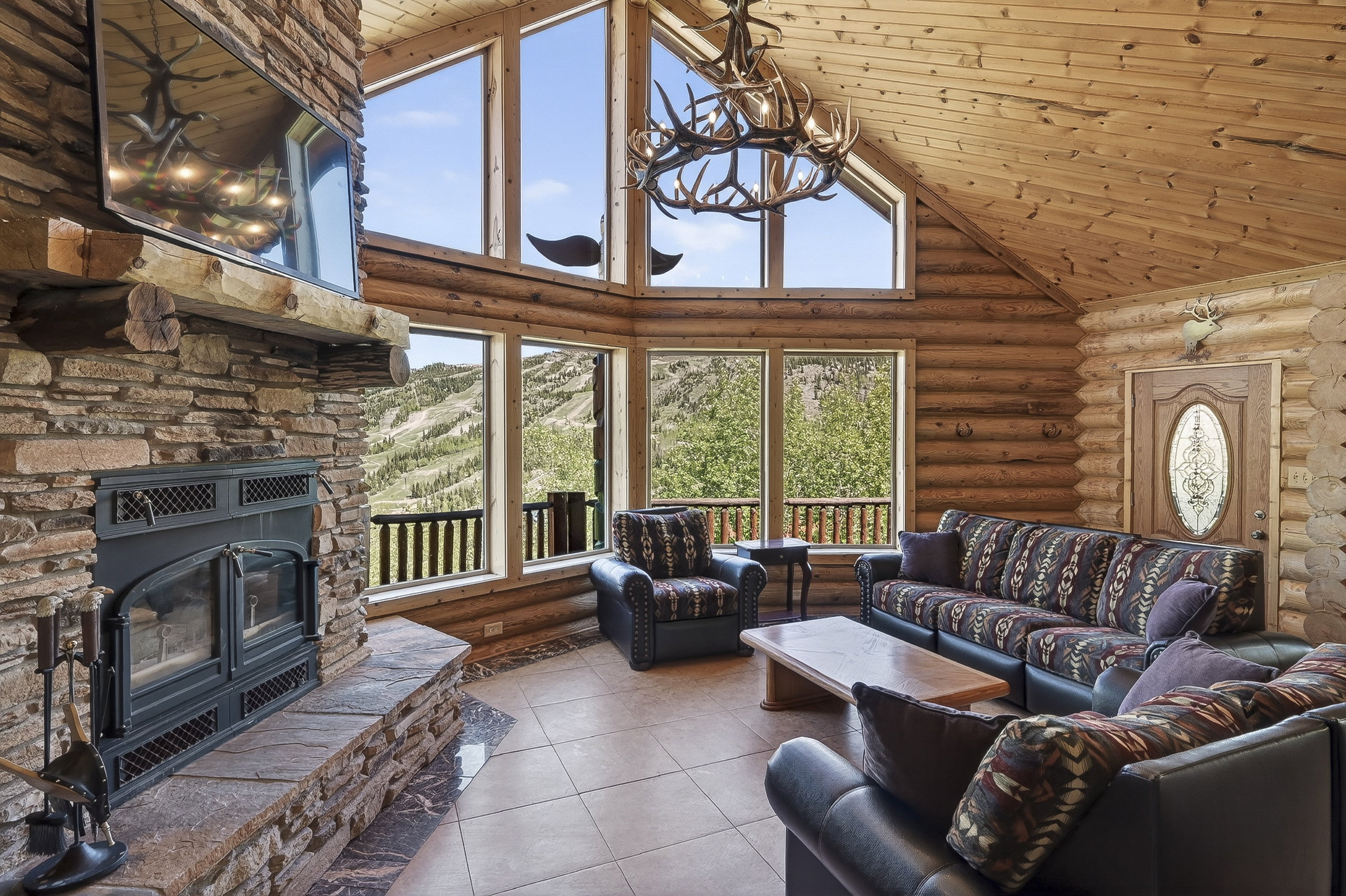 Vaulted wood-paneled ceiling with a decorative antler chandelier