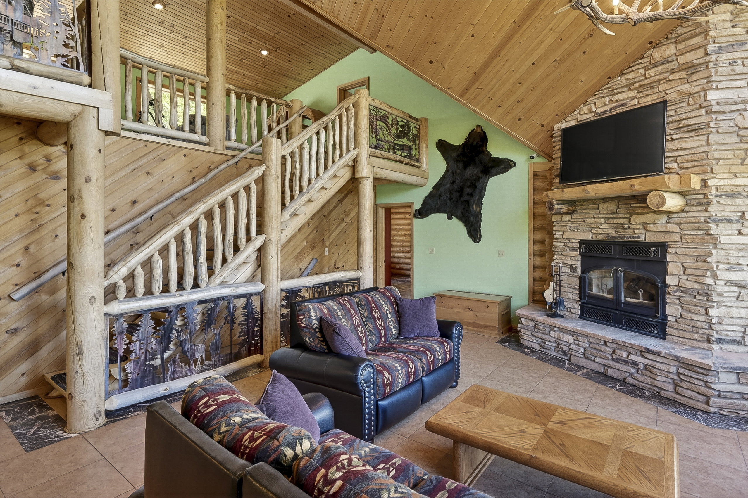 Vaulted wood-finish ceilings and walls complement the prominent stone-finish fireplace