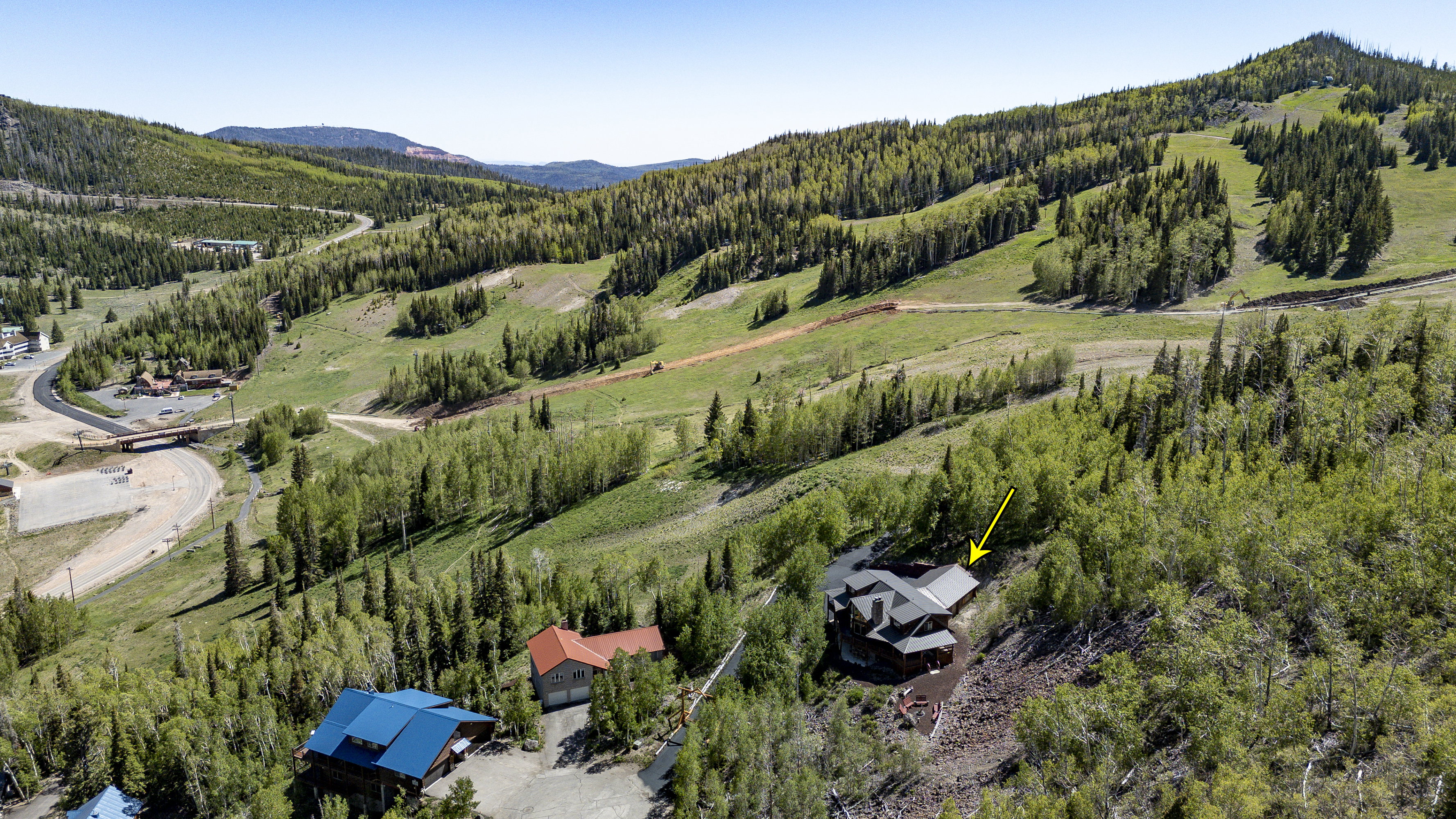 Mountain-side property featuring a multi-level structure with a dark roofline