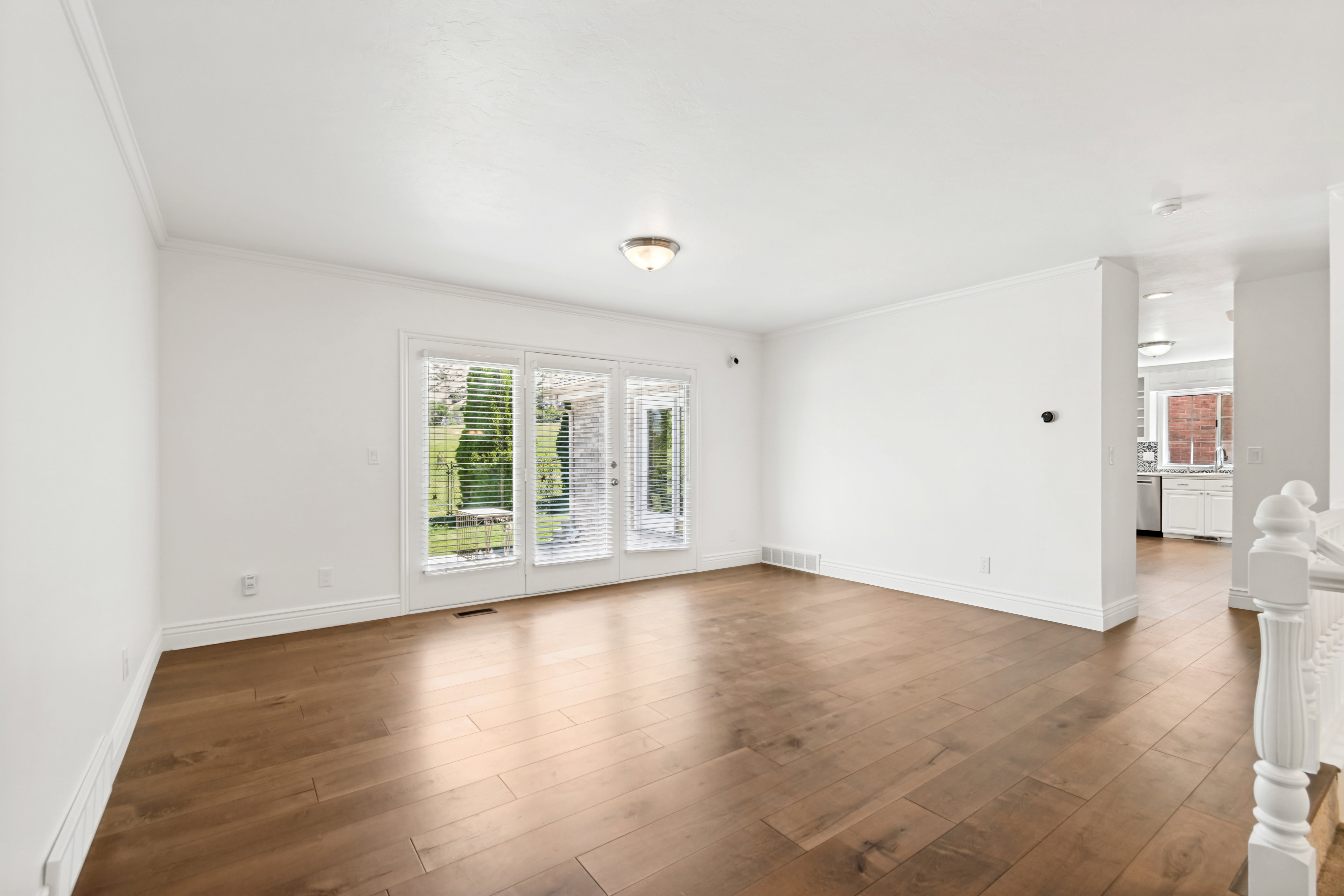 Spacious interior featuring wood-finish flooring, white walls, and bright overhead lighting