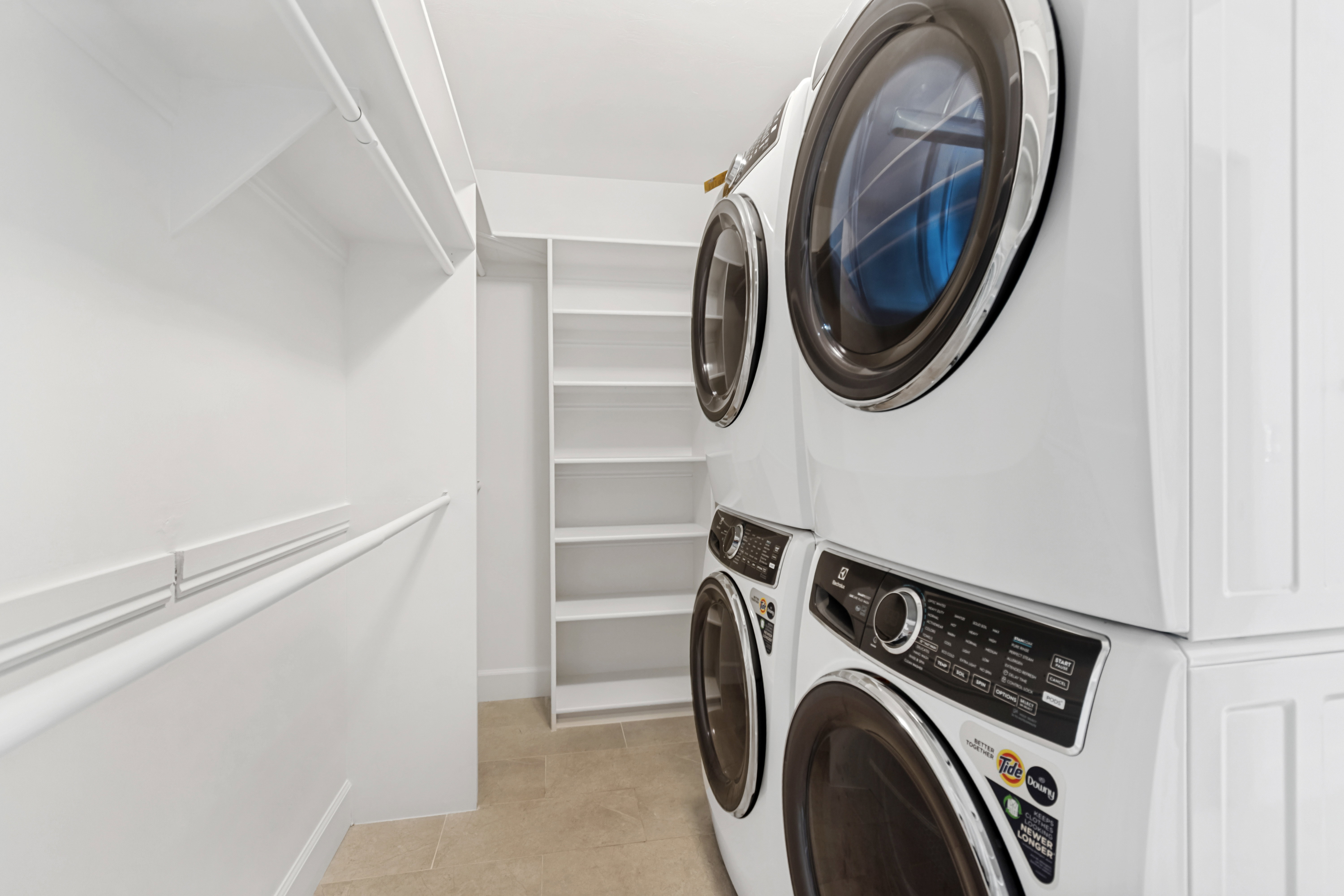 Dedicated laundry area featuring stacked front-load washer and dryer units