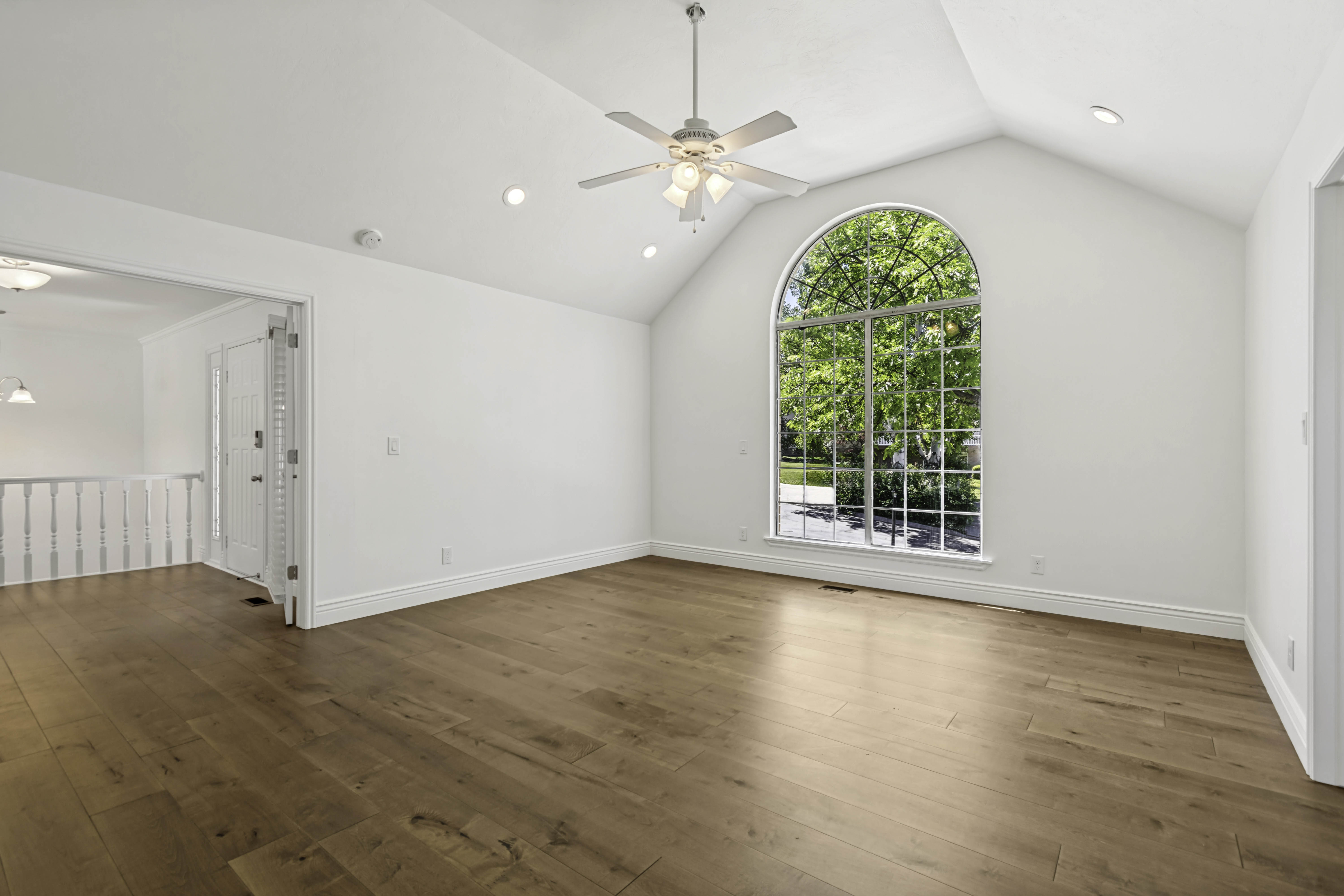 Spacious room with a vaulted ceiling, recessed lighting, and a ceiling fan