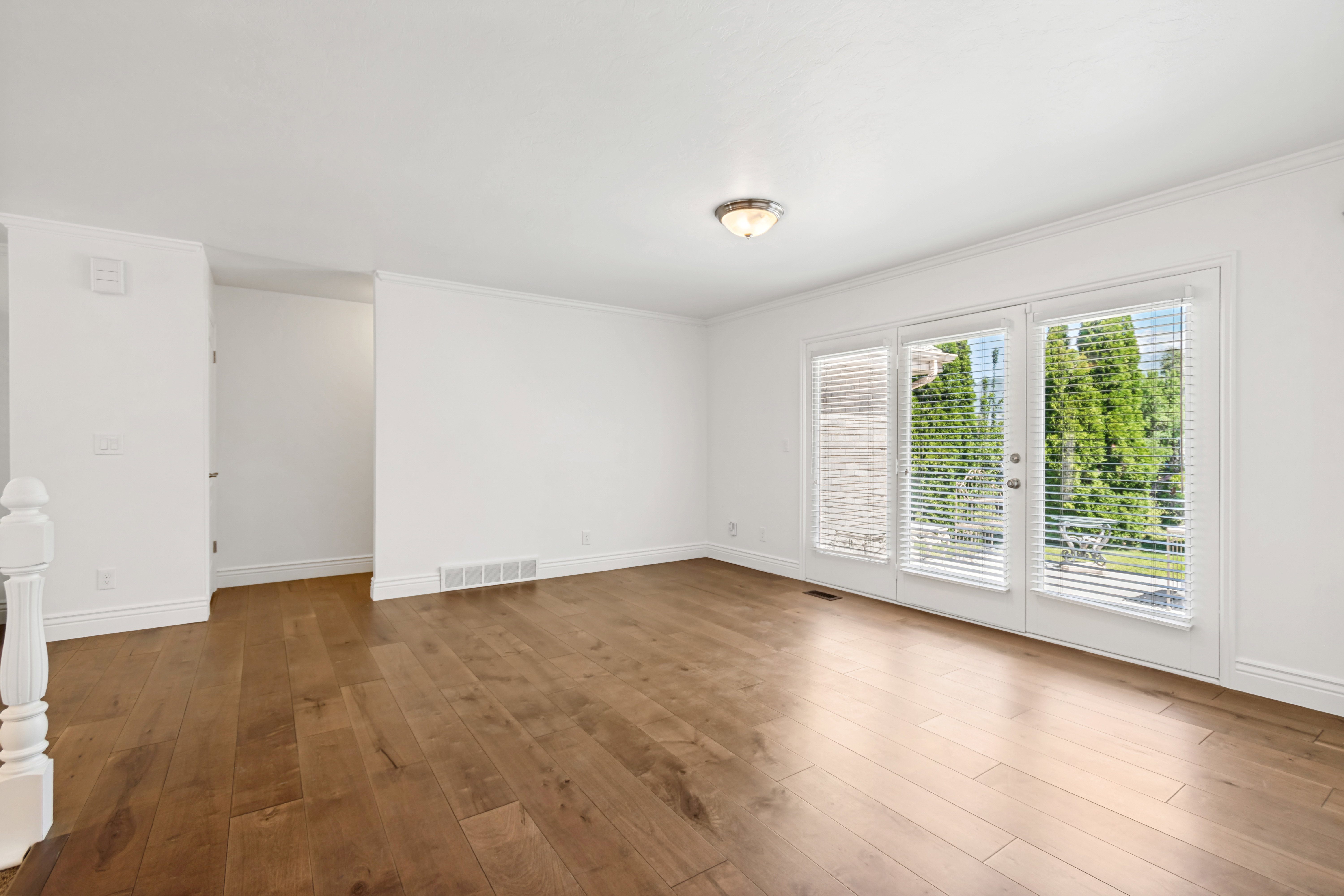 Bright interior space featuring wood-finish flooring, white walls, and a ceiling-mounted light fixture
