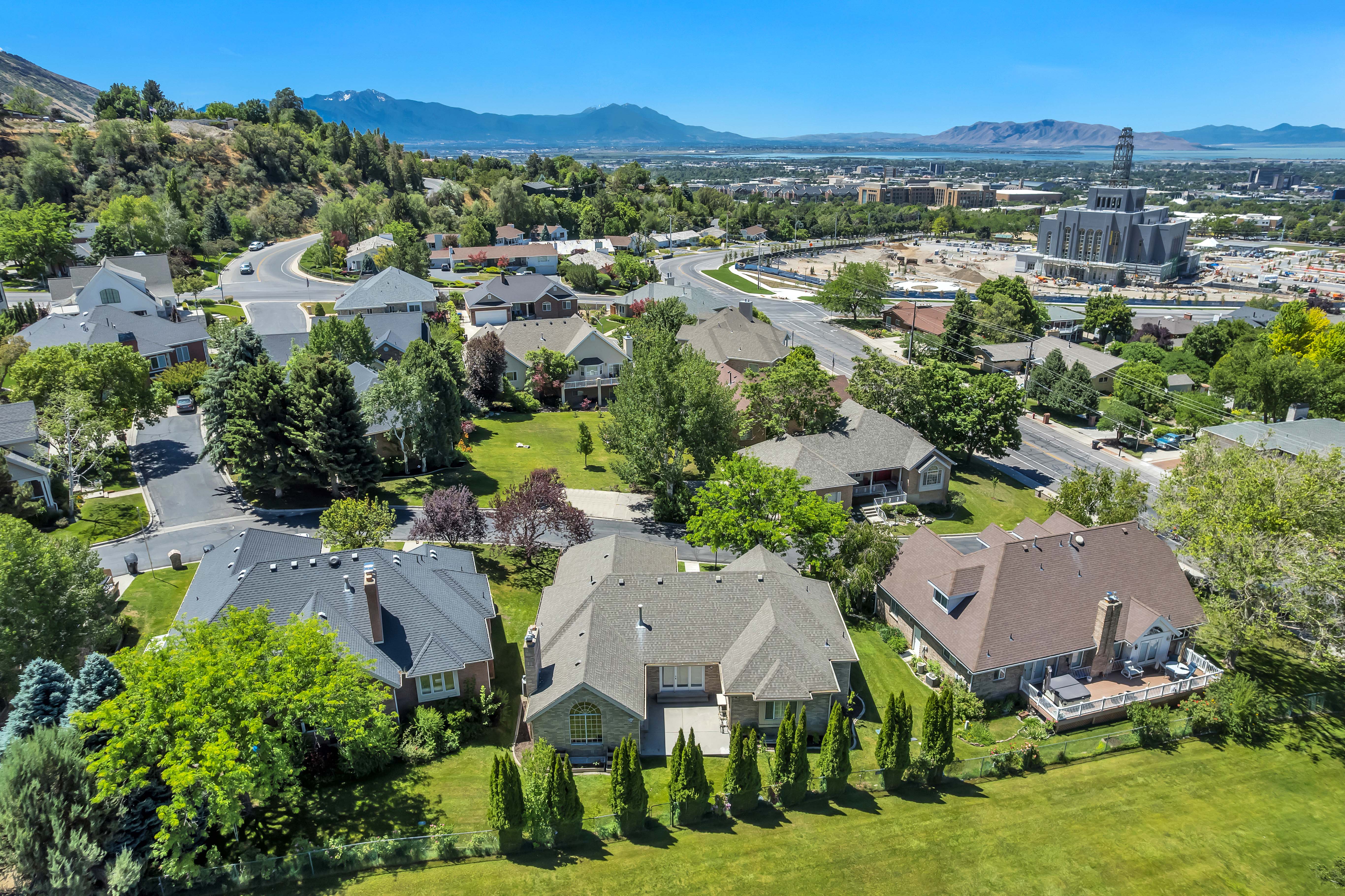 Aerial perspective of a neighborhood featuring residential properties with manicured lawns and mature trees