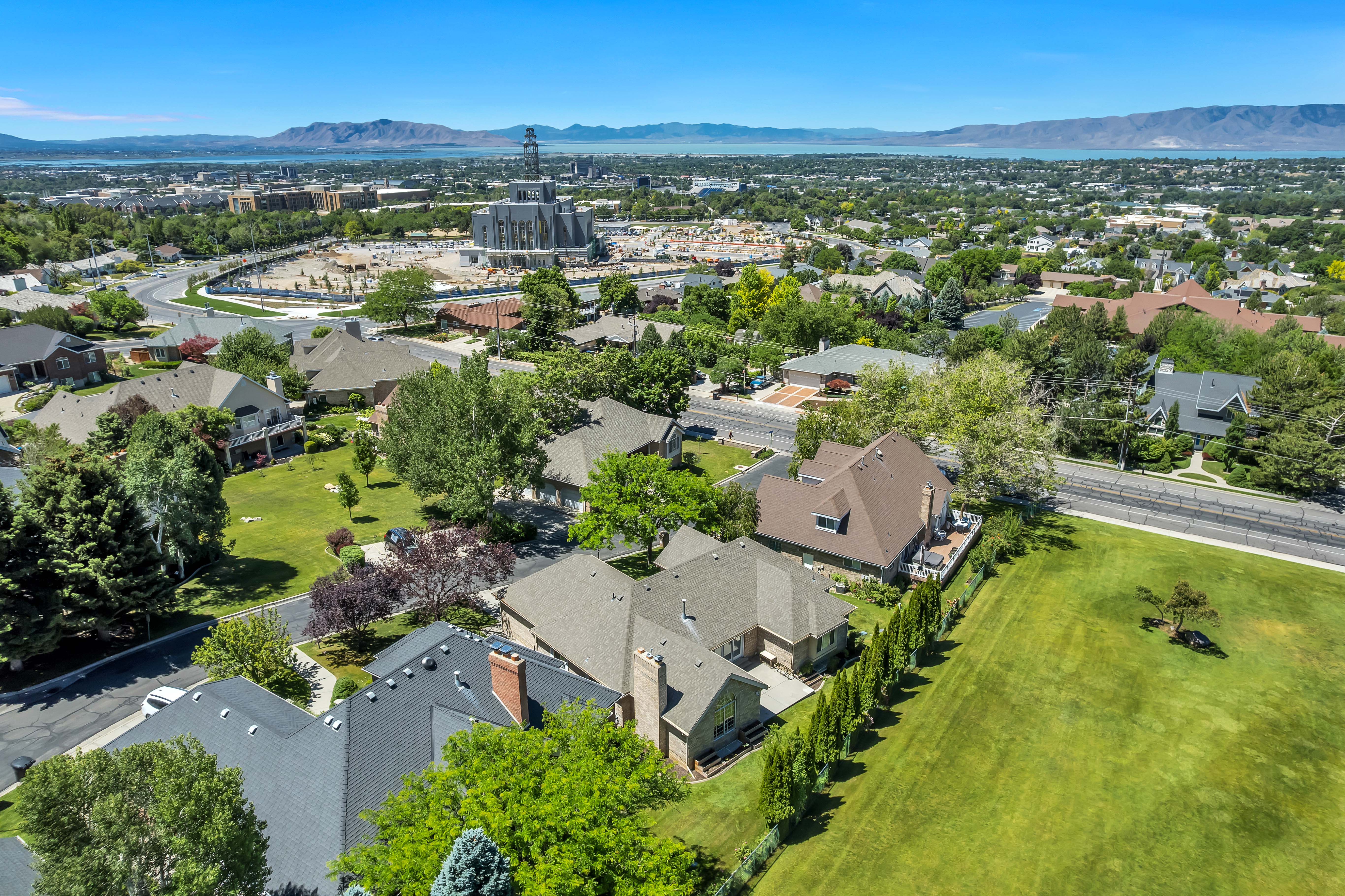 Expansive suburban landscape featuring a variety of architectural styles, mature trees, and manicured green spaces