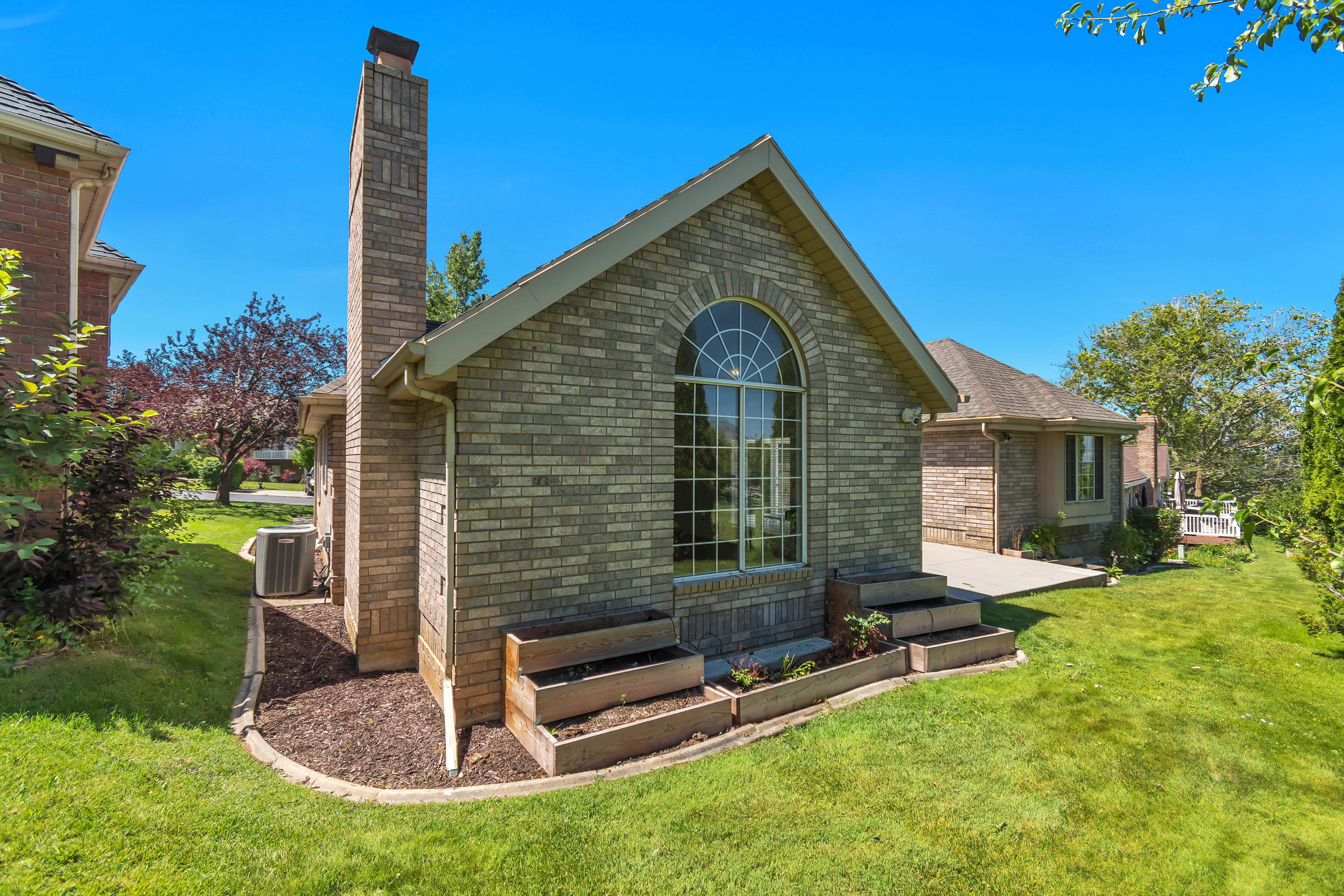 Brick exterior with a prominent arched window, complemented by a tall brick chimney