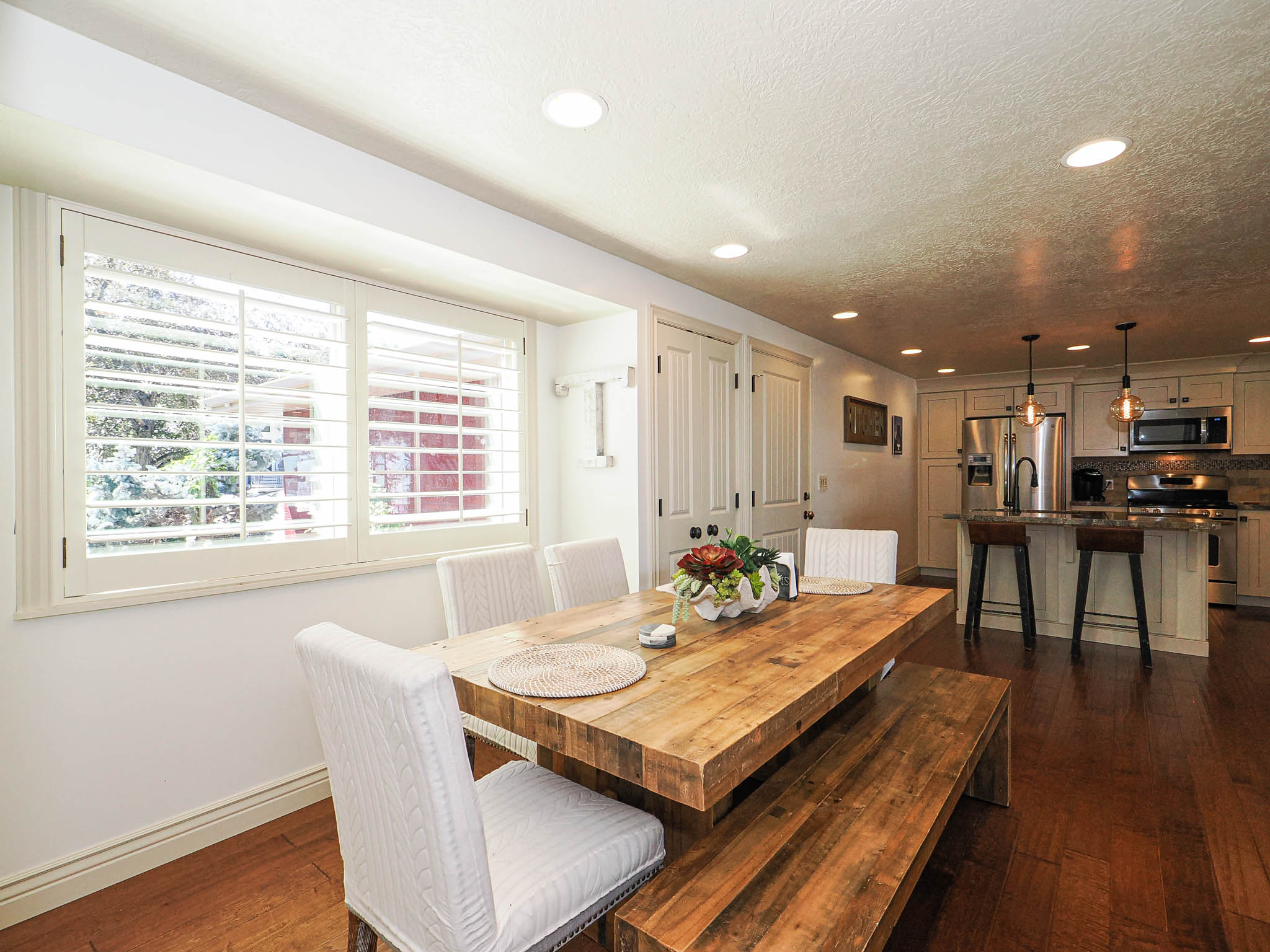 Dining area featuring wood-finish flooring, recessed lighting, and a window with plantation shutters