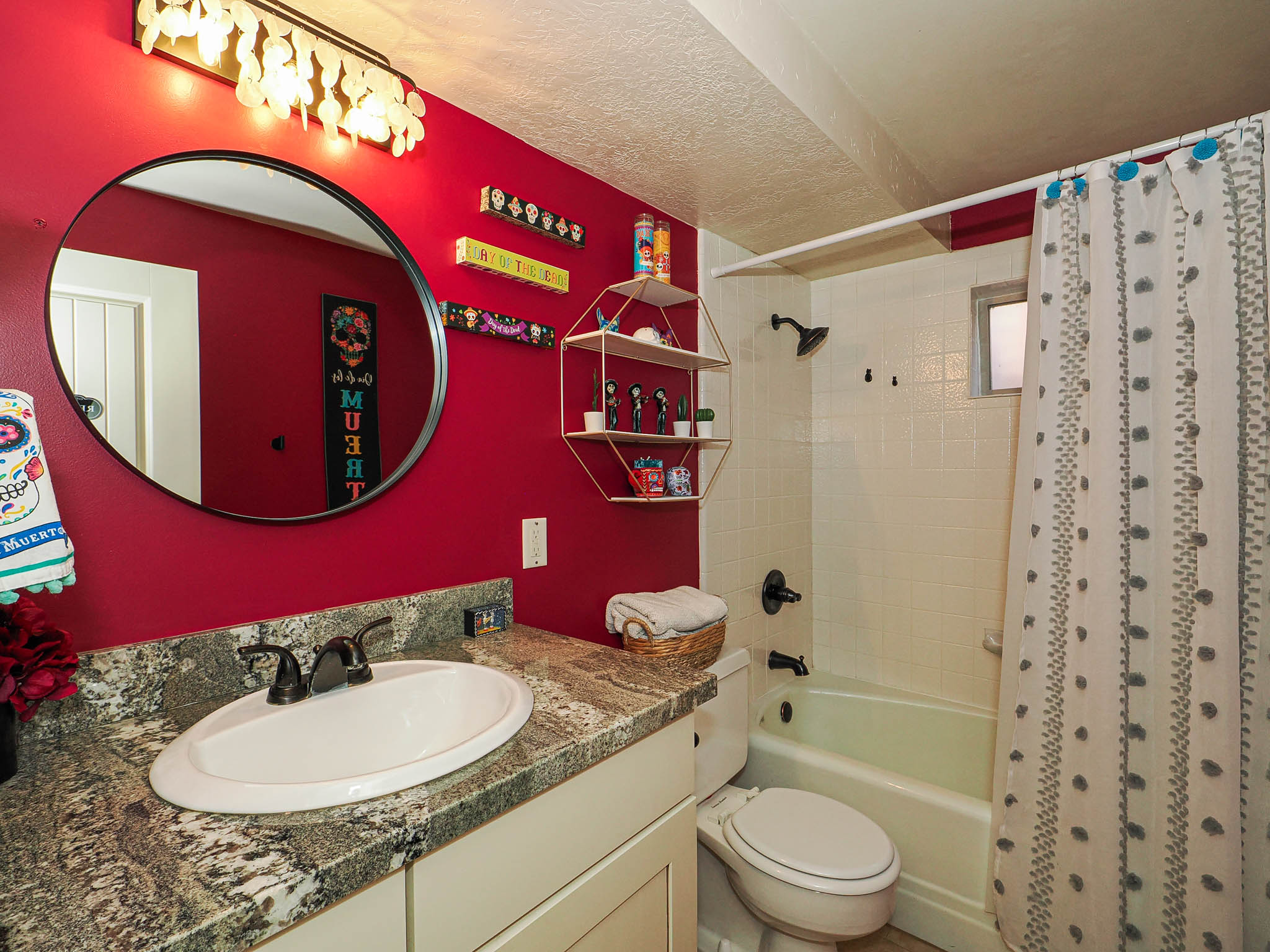 Bathroom featuring a single vanity with an oval undermount sink, a patterned countertop, and a dark bronze faucet