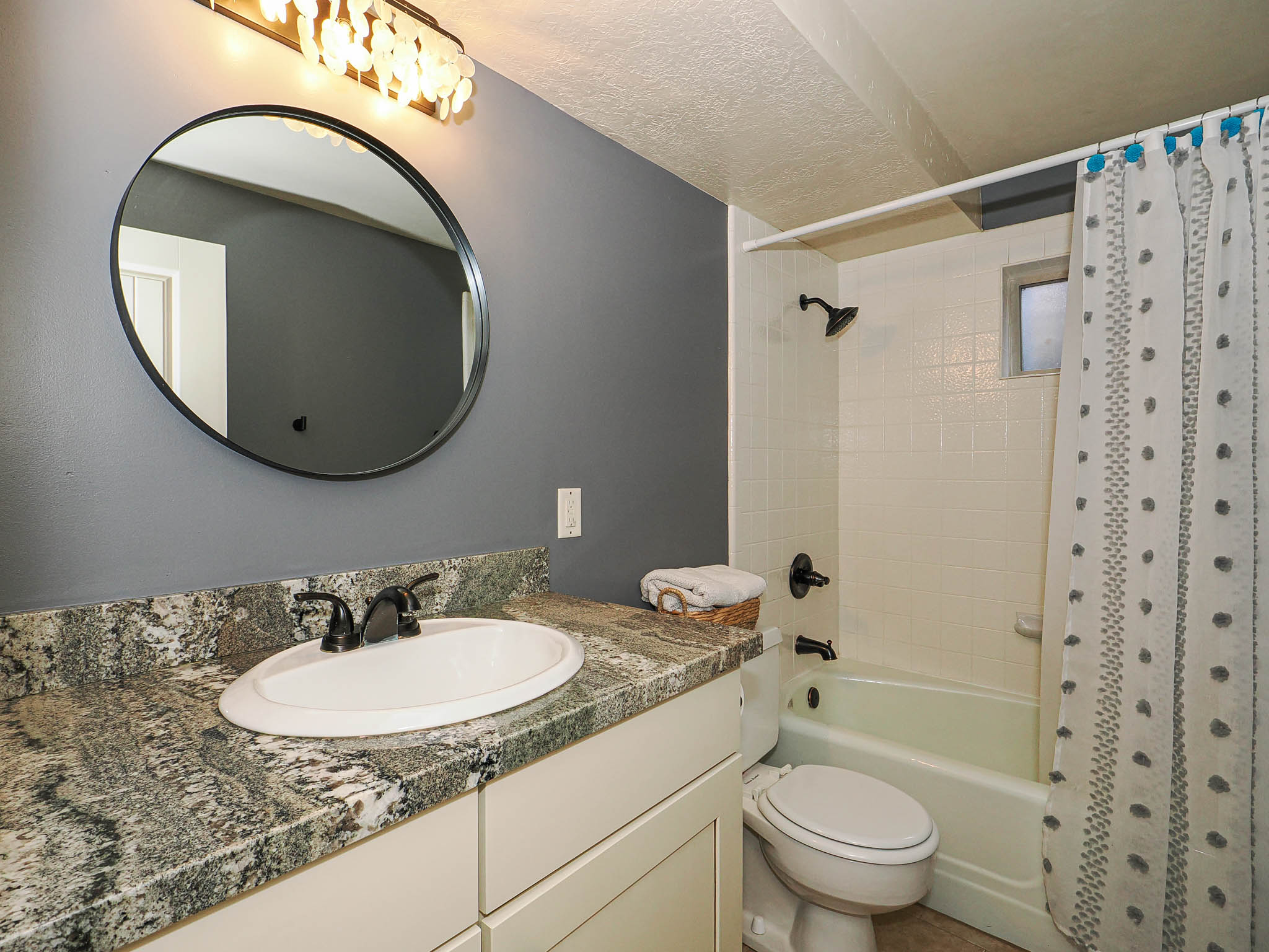 Bathroom featuring a vanity with a patterned countertop, an undermount sink, and dark bronze fixtures