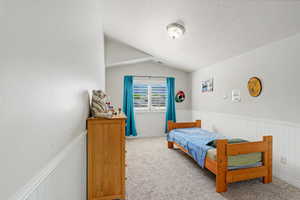 Room featuring neutral wall paint, white wainscoting, and carpeted flooring