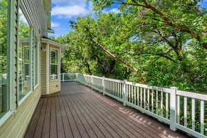 Expansive outdoor deck featuring composite decking, white railing, and exterior wall lighting