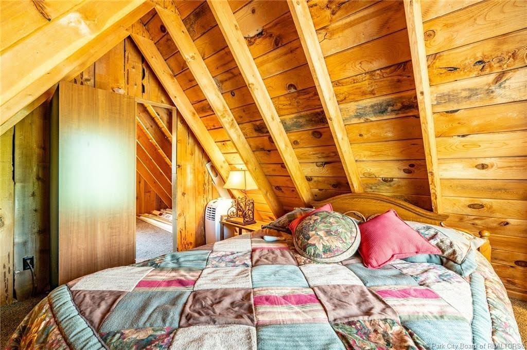 Sloped wood-paneled ceiling with exposed beams
