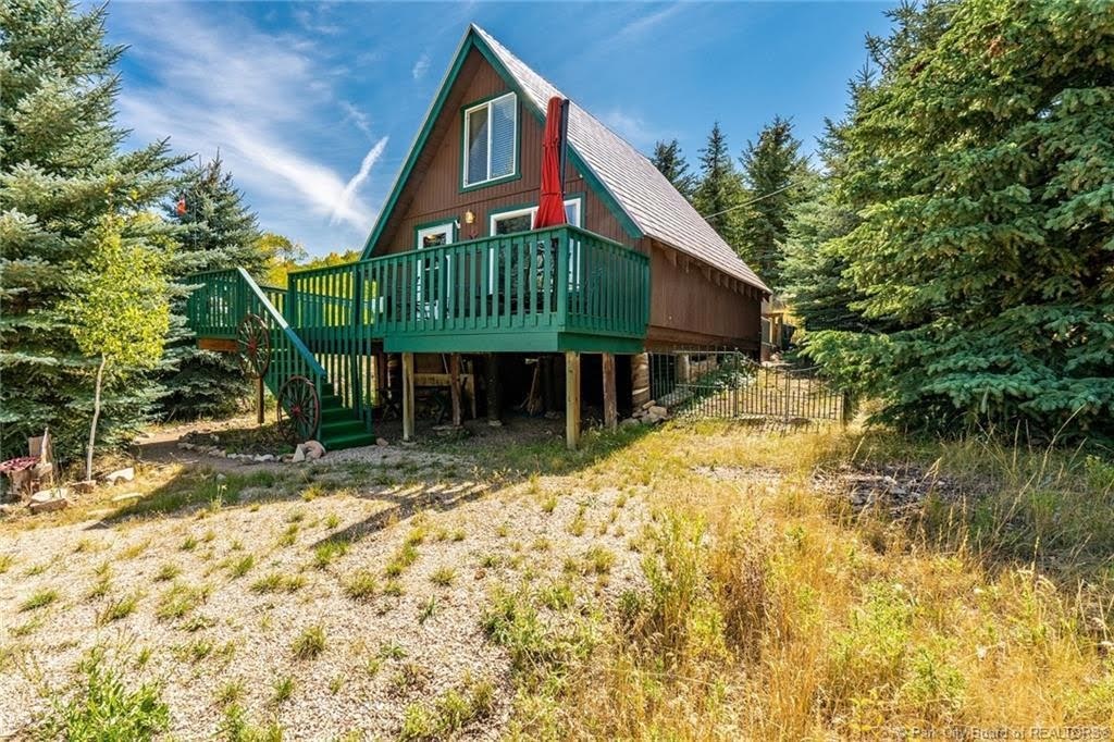 A-frame residence featuring a brown exterior siding and a grey shingled roof