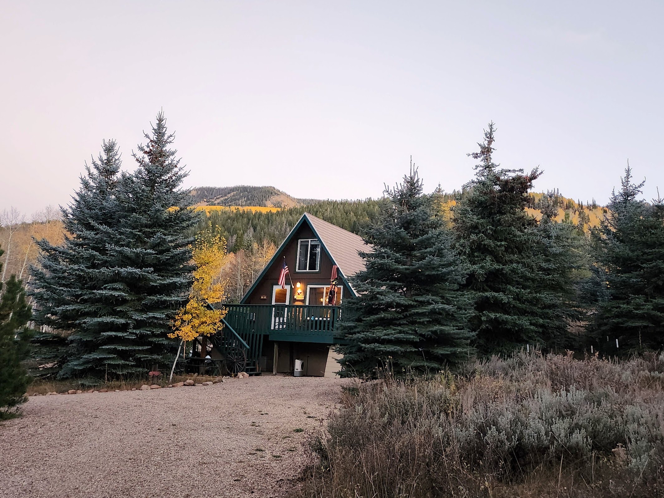 A-frame residence with a dark brown exterior and a dark green deck