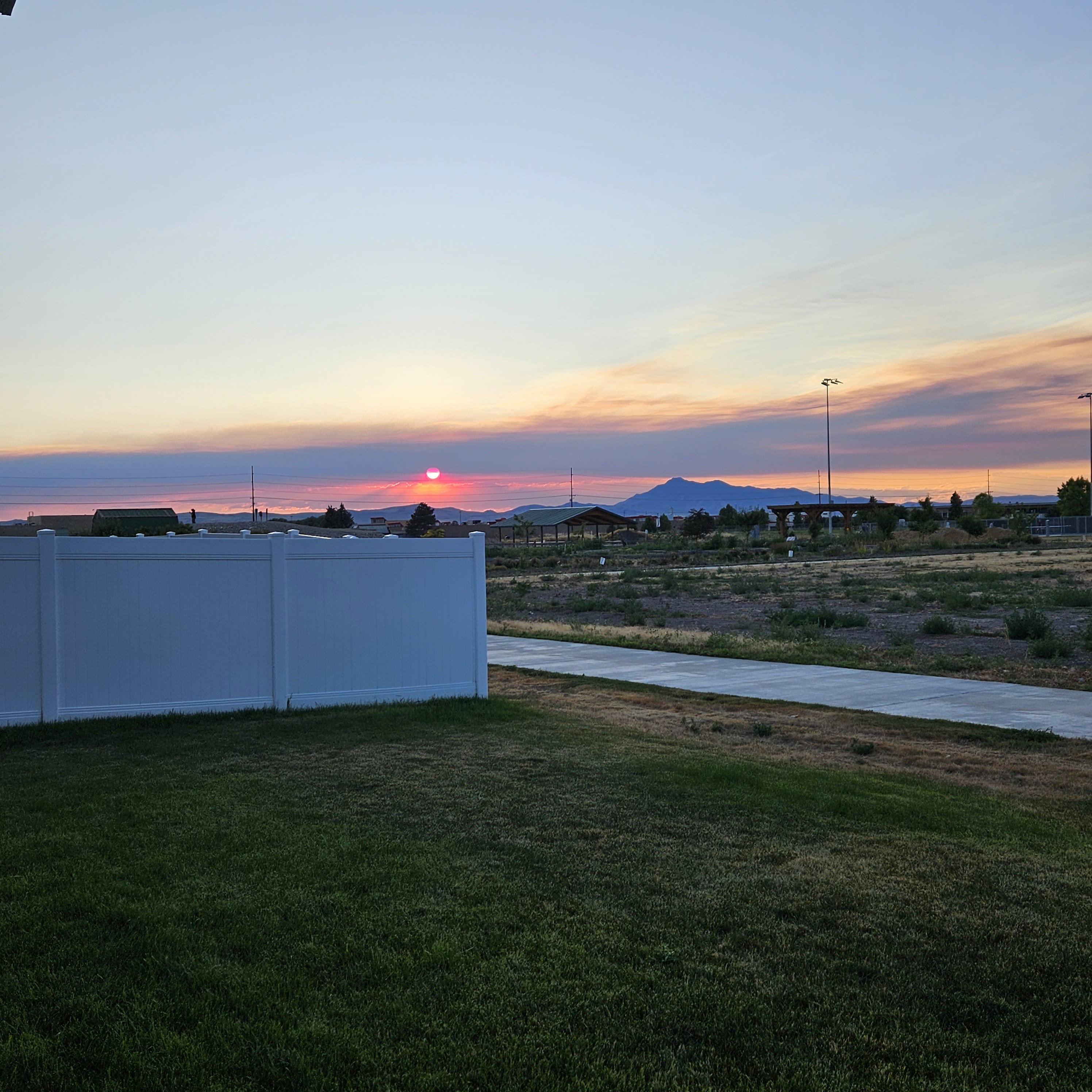 Expansive green lawn with a white vinyl fence