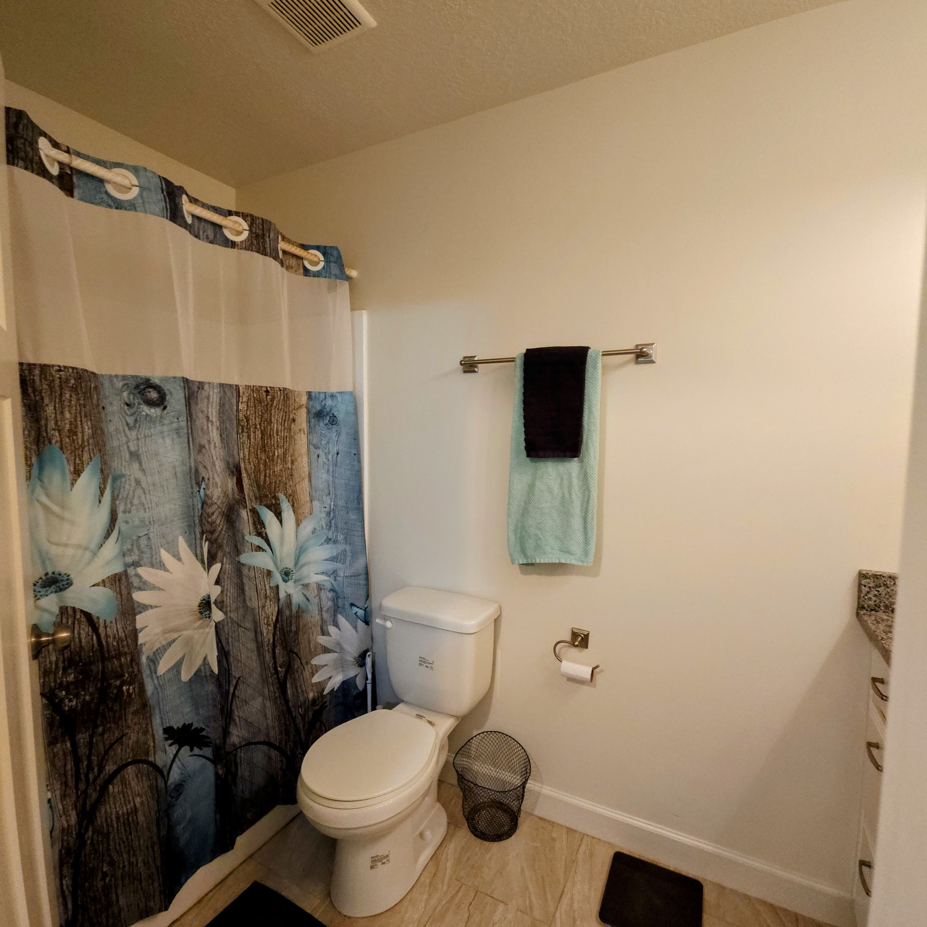 Bathroom featuring a shower-tub combination, a standard toilet, and tiled flooring