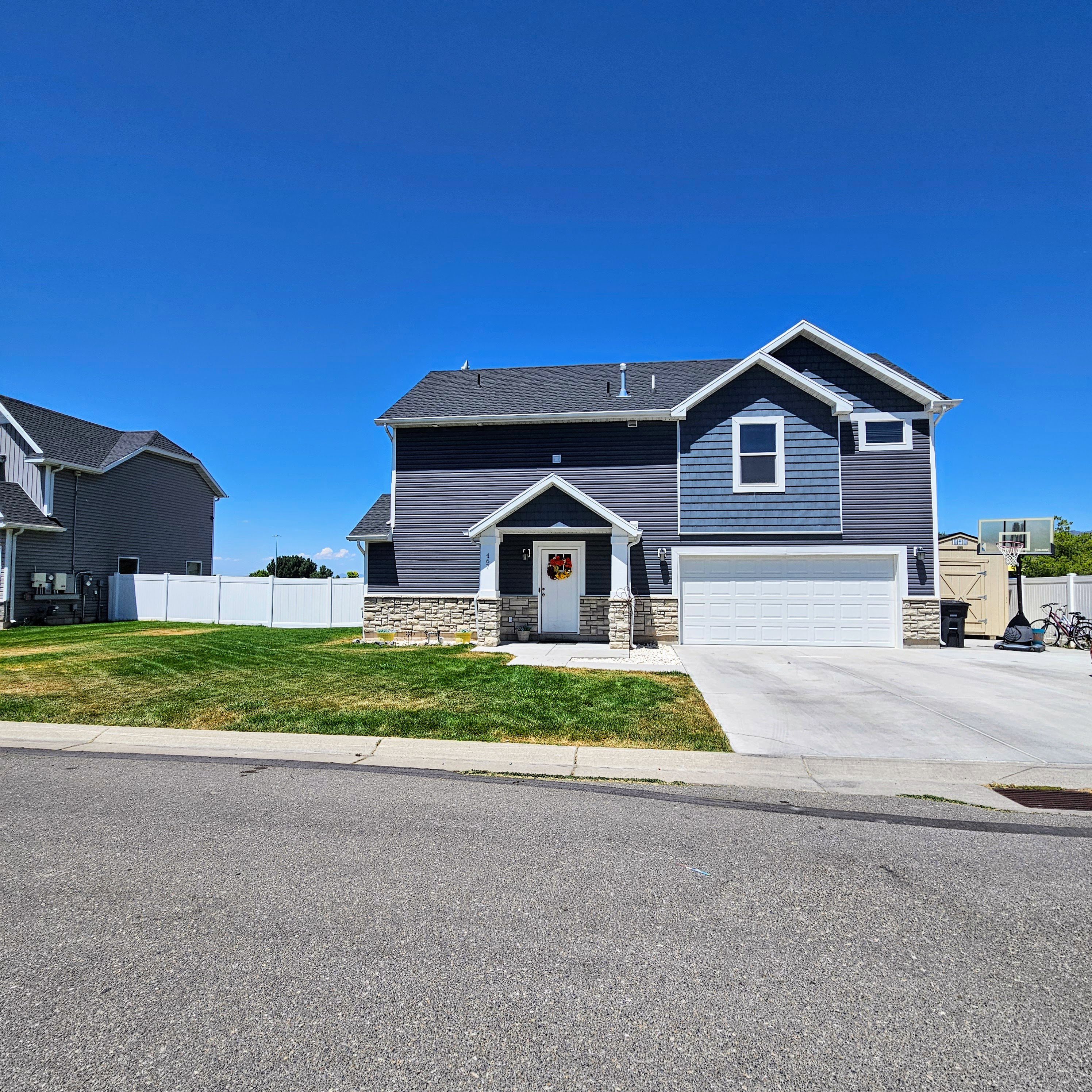 Two-story residence featuring a dark blue siding exterior with light blue accent siding and stone detailing