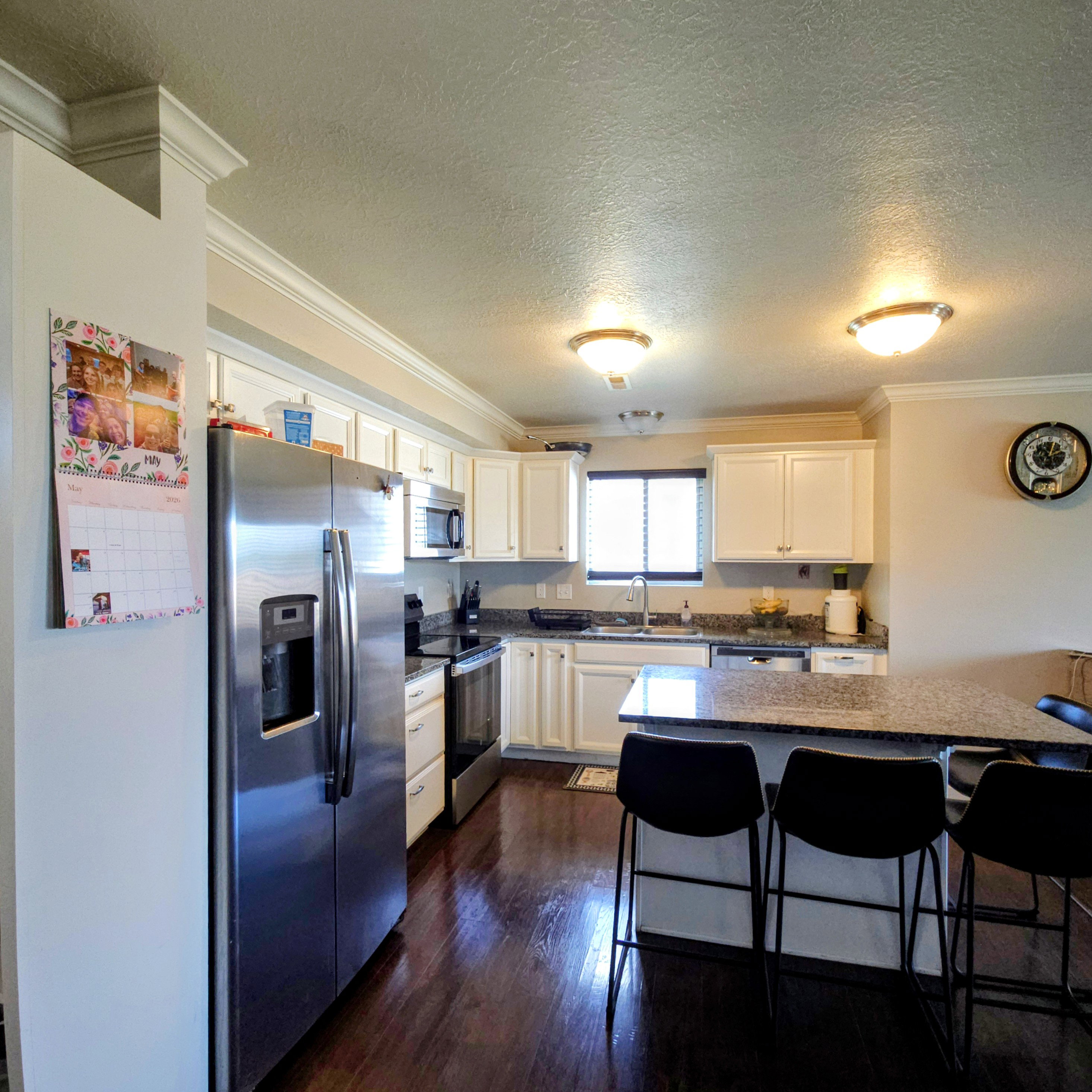 Kitchen featuring wood-finish flooring, white cabinetry, and a stainless steel appliance suite