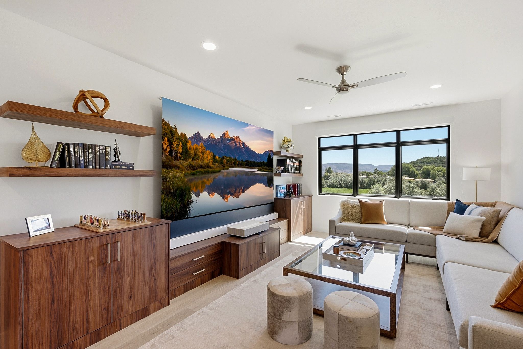 Living area featuring a large window, built-in shelving, wood-finish cabinetry, recessed lighting, and a ceiling fan