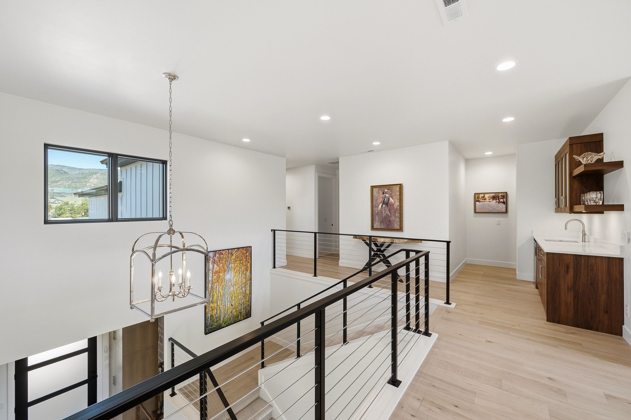 Upper-level landing featuring a wet bar with a white countertop and wood-finish cabinetry